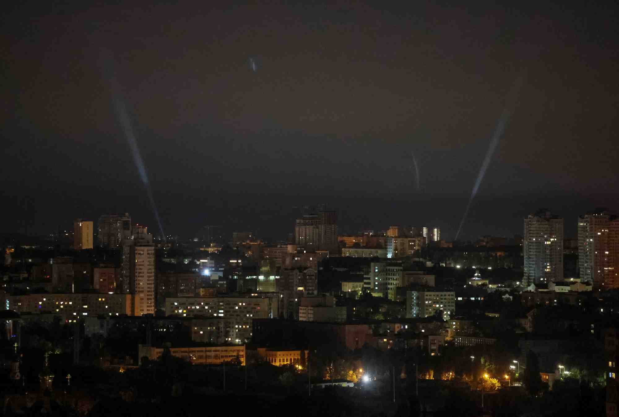 Des militaires ukrainiens utilisent un projecteur pour rechercher des drones dans le ciel de la ville