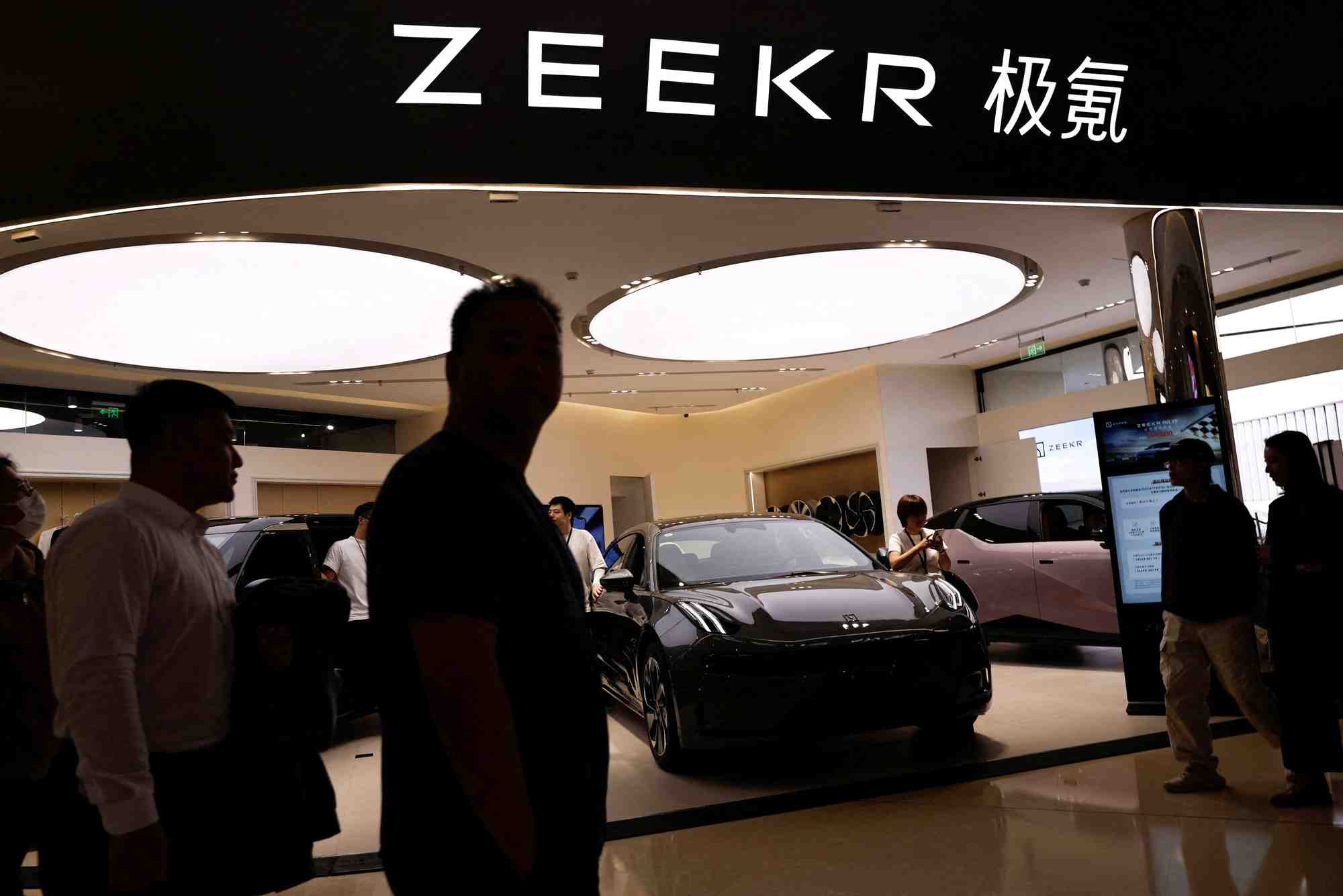 Photo d'archives: des personnes passent devant un stand de zeekr, la marque de vehicules electriques haut de gamme du constructeur automobile chinois geely, dans un centre commercial de pekin