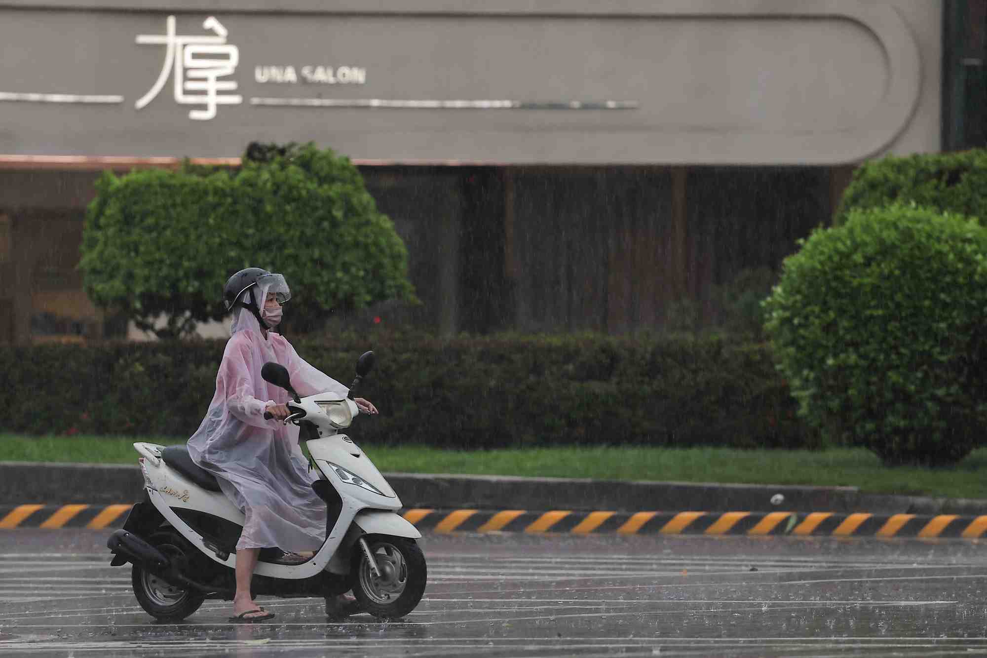 Une personne sur une motocyclette s'arrete a un signal alors que le typhon krathon approche a kaohsiung, taiwan