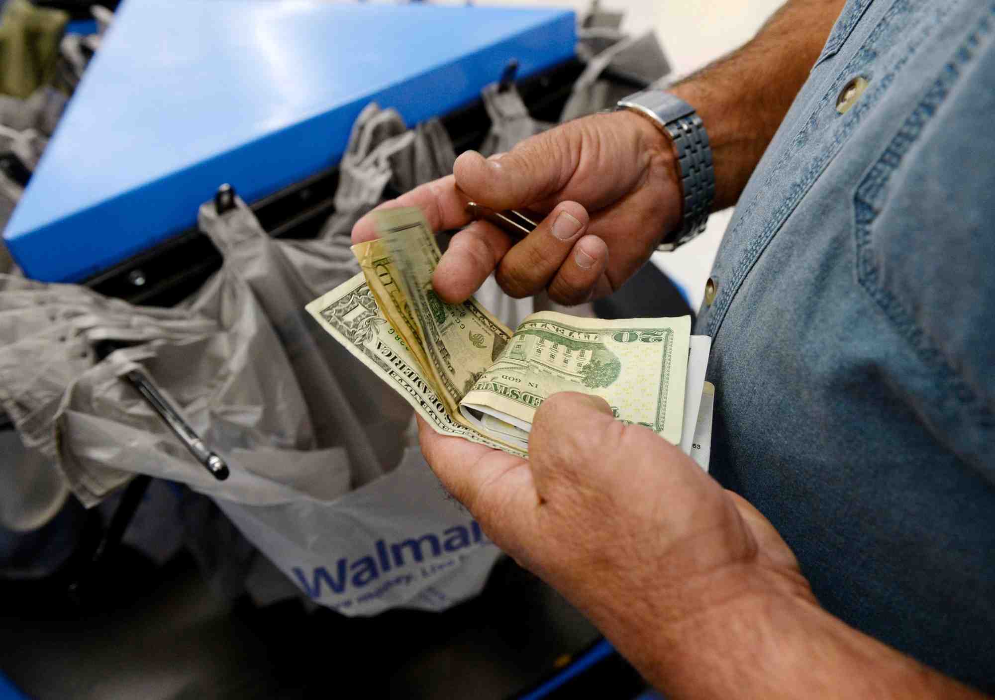 Un client compte son argent a la caisse d'un magasin walmart dans le quartier de porter ranch a los angeles.
