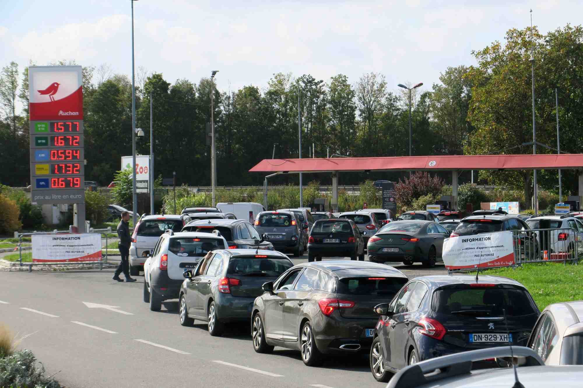 Des automobilistes font la queue pour remplir leur reservoir d'essence aux pompes de la station-service auchan de petite-foret