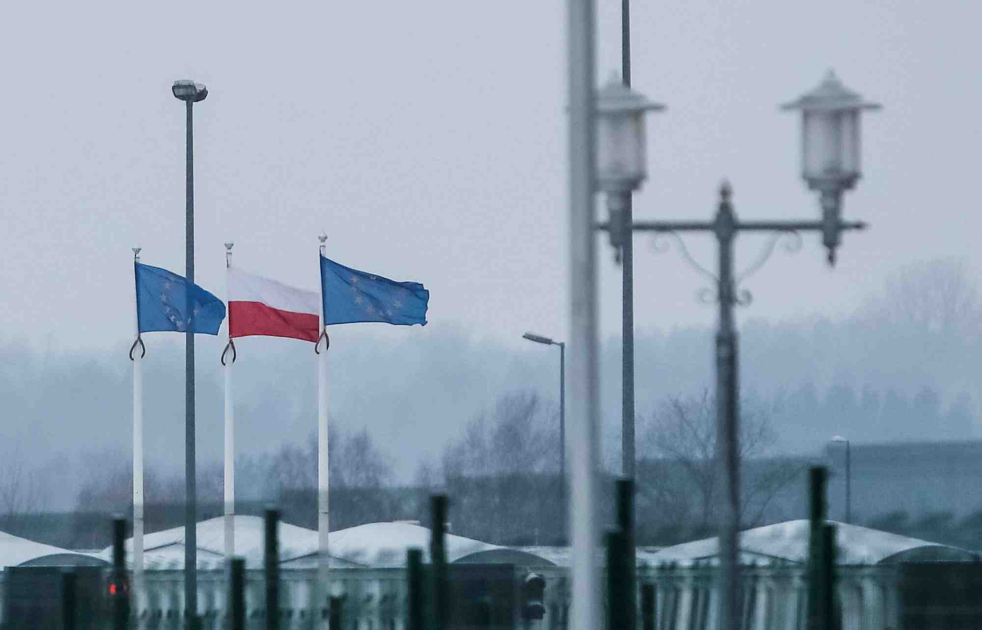Une vue sur la frontiere bielorusse-polonaise montre des drapeaux polonais et europeens derriere une cloture