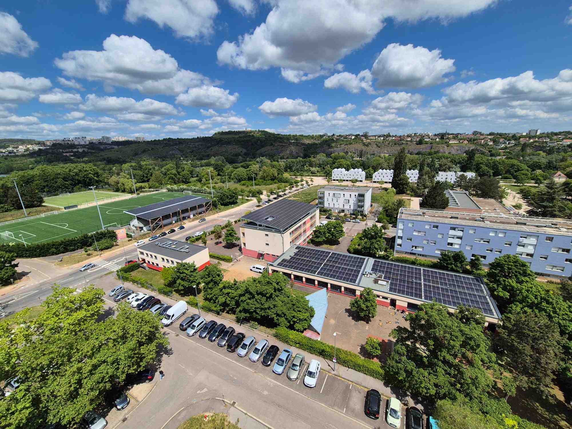 Vue sur le stade de football, et une des écoles équipées de panneaux photovoltaiques dans le quartier à énergie positive de Dijon : La Fontaine d'Ouche