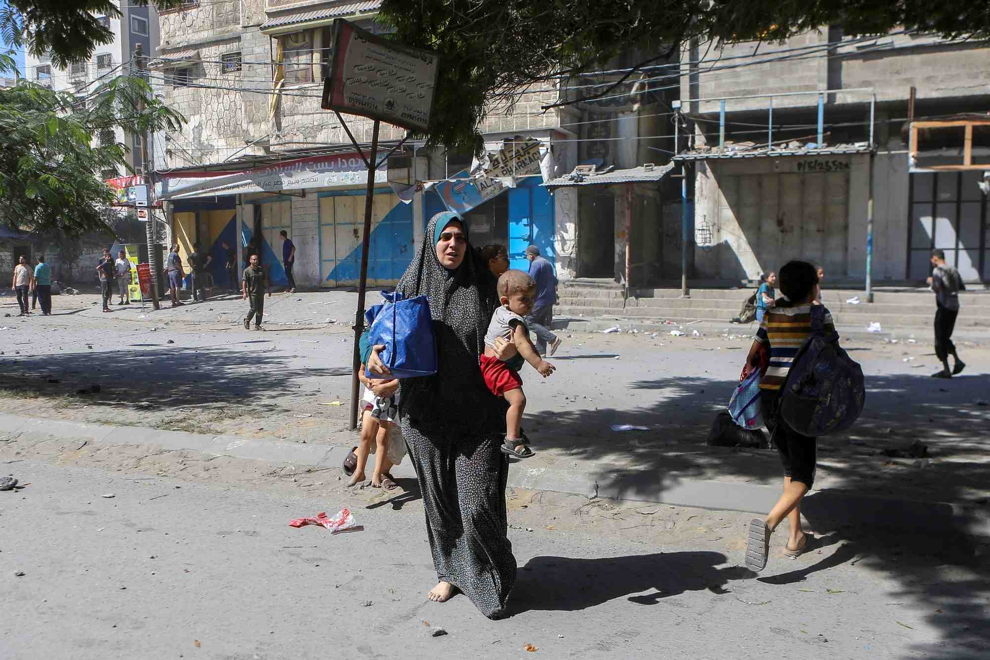 Des palestiniens marchent dans les rues de gaza lors des frappes israeliennes