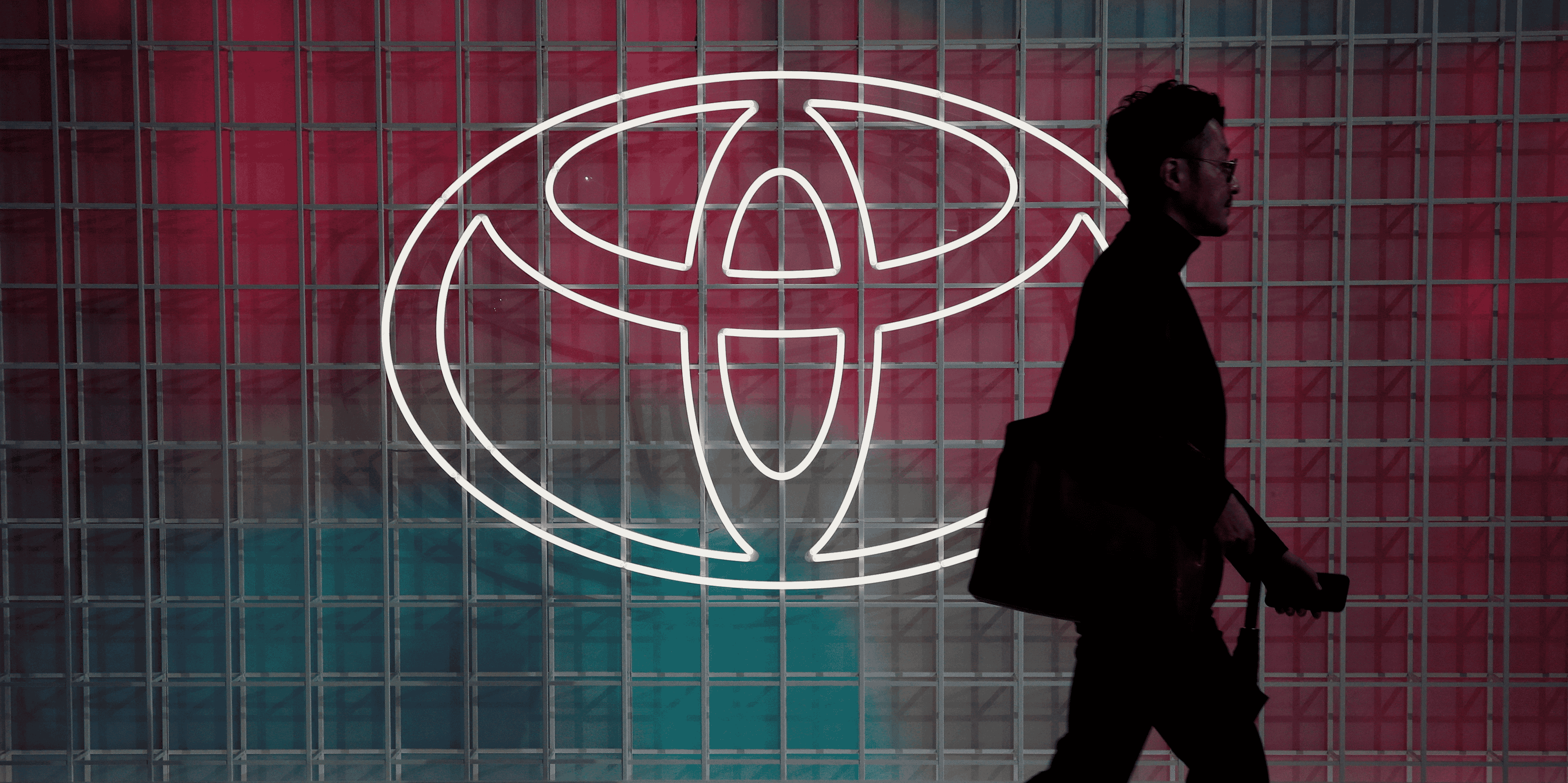 Un homme passe devant un logo toyota