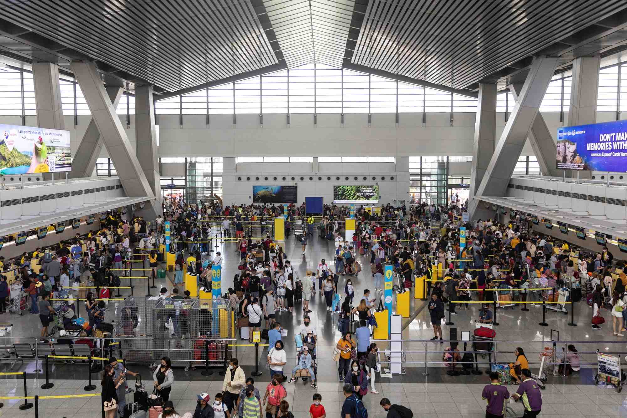 Des passagers font la queue pour s'enregistrer a l'aeroport international ninoy-aquino, aux philippines