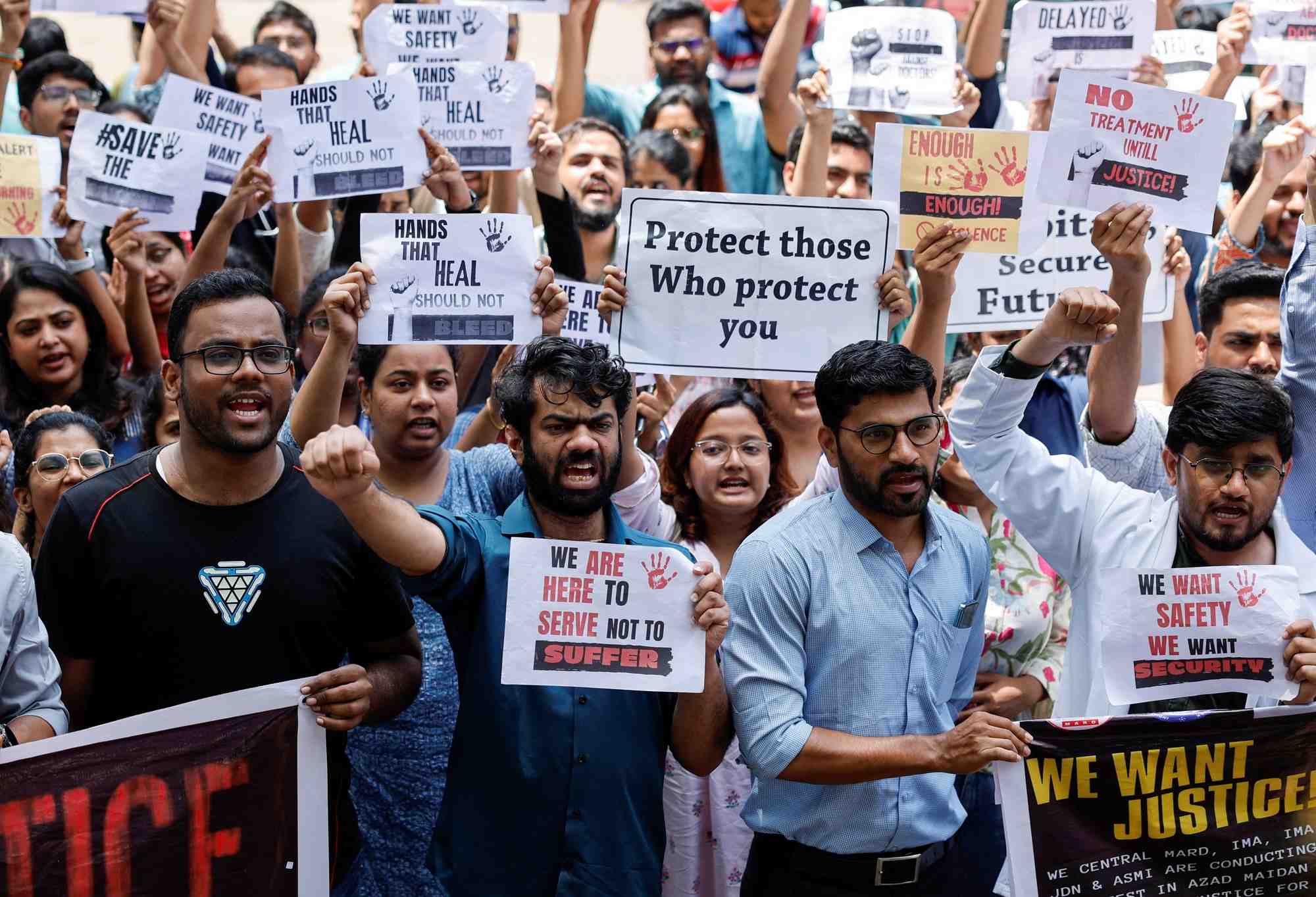 Le personnel medical crie des slogans en tenant des pancartes lors d'une manifestation dans un hopital de mumbai.