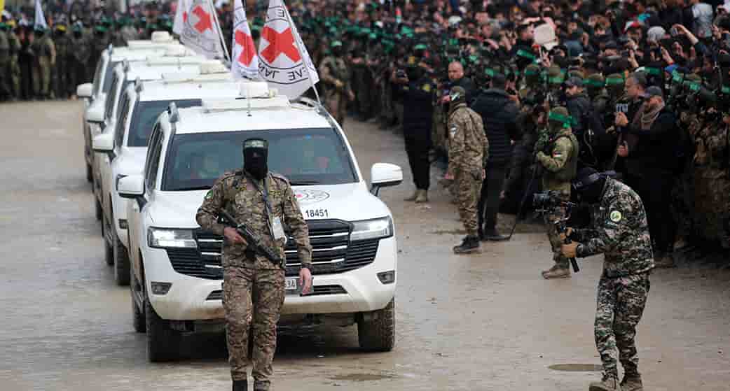 Un palestinien du Hamas précède des véhicules de la Croix-Rouge internationale (CICR) qui arrivent à Nuseirat, pour accueillir trois otages israéliens dans le cadre du septième échange d'otages et de prisonniers, le 22 février 2025.
