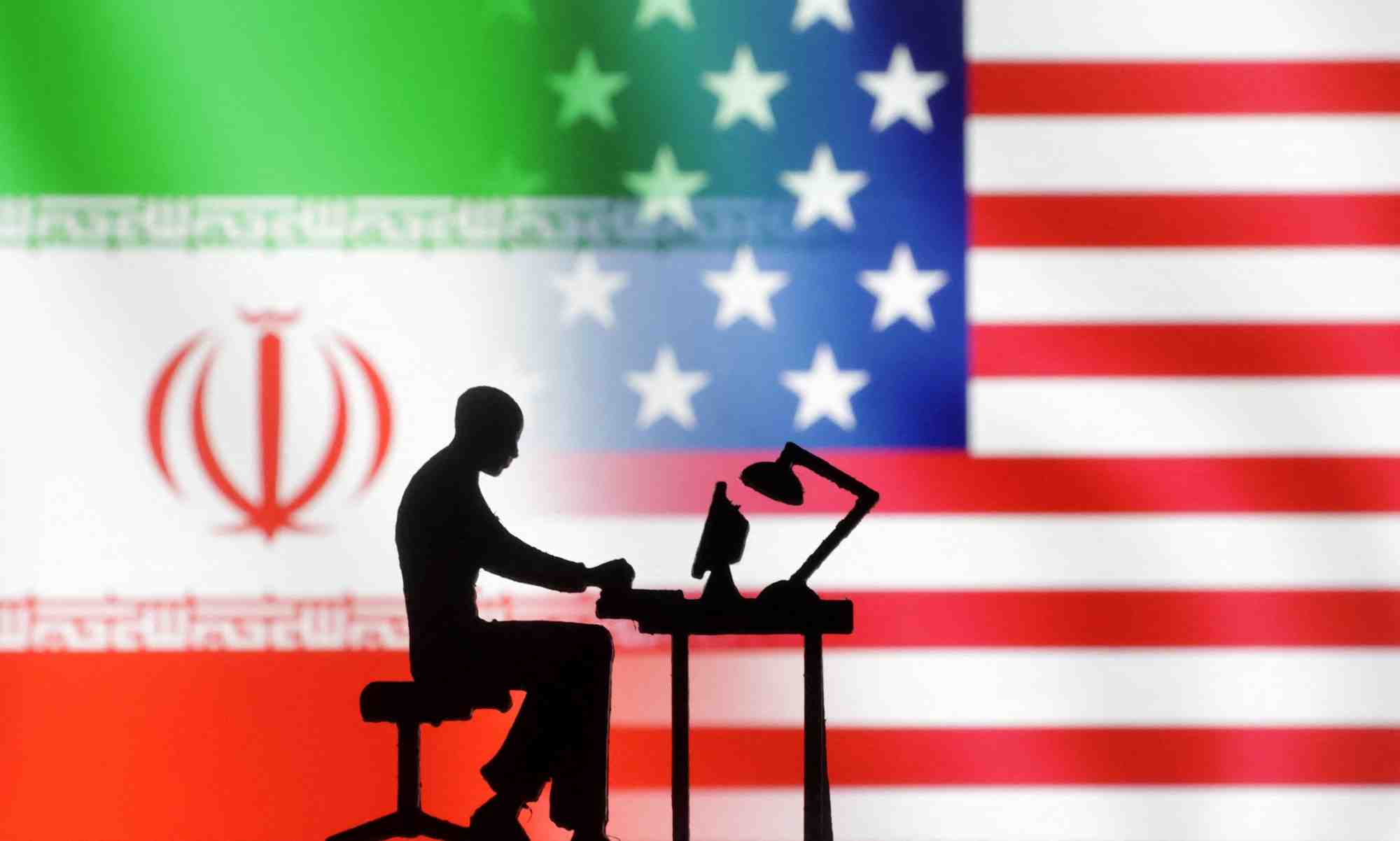 Photo d'illustration d'archives de figurines et d'ordinateurs devant les drapeaux americain et iranien
