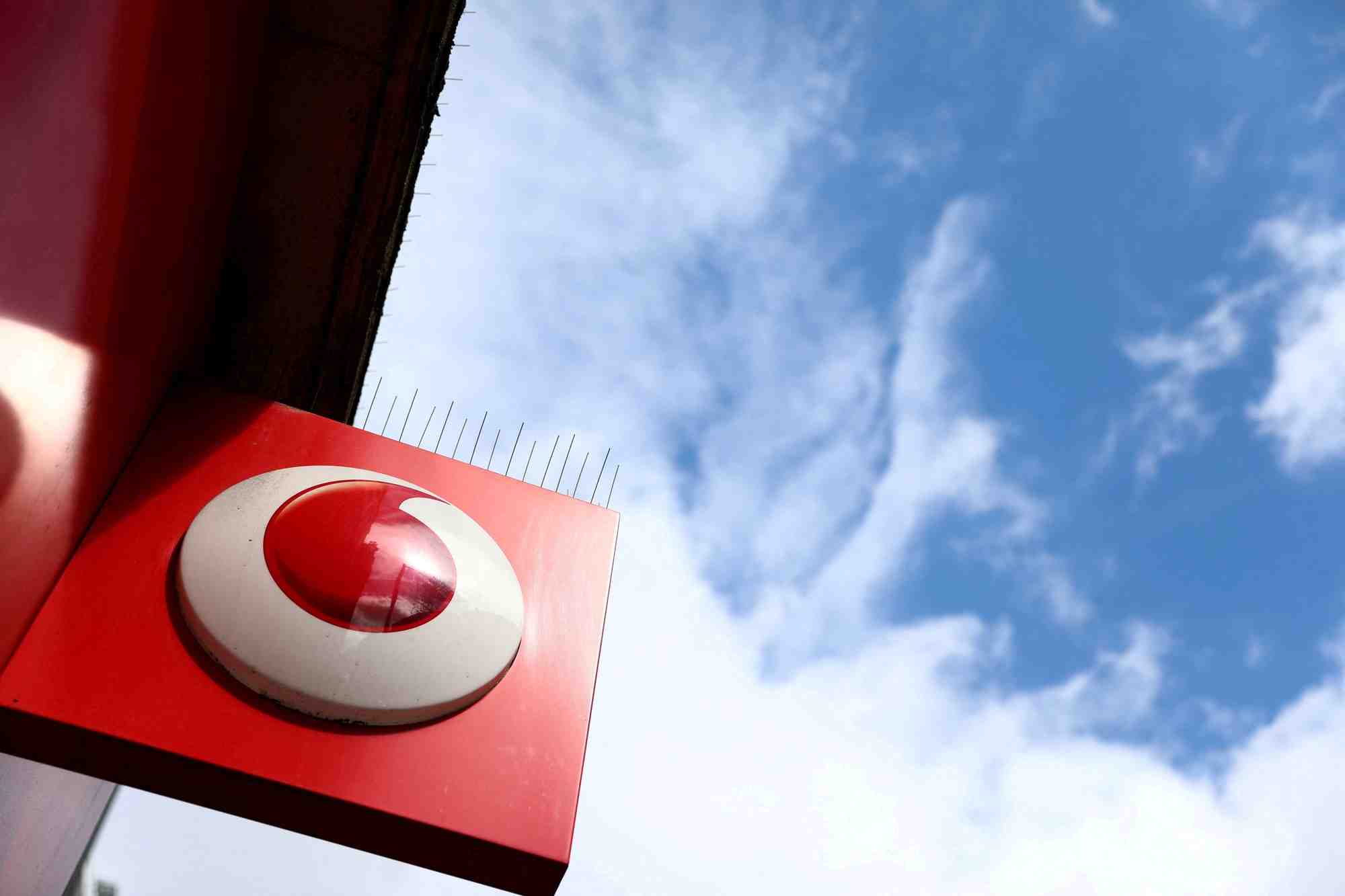 Le logo de vodafone est affiche sur un panneau devant un magasin a londres