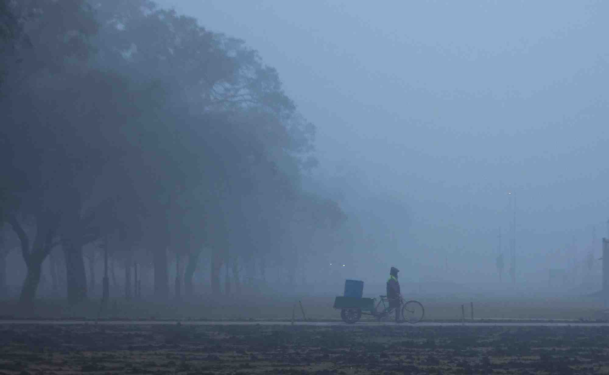 Un homme marche pres de l'india gate par une froide matinee d'hiver a new delhi