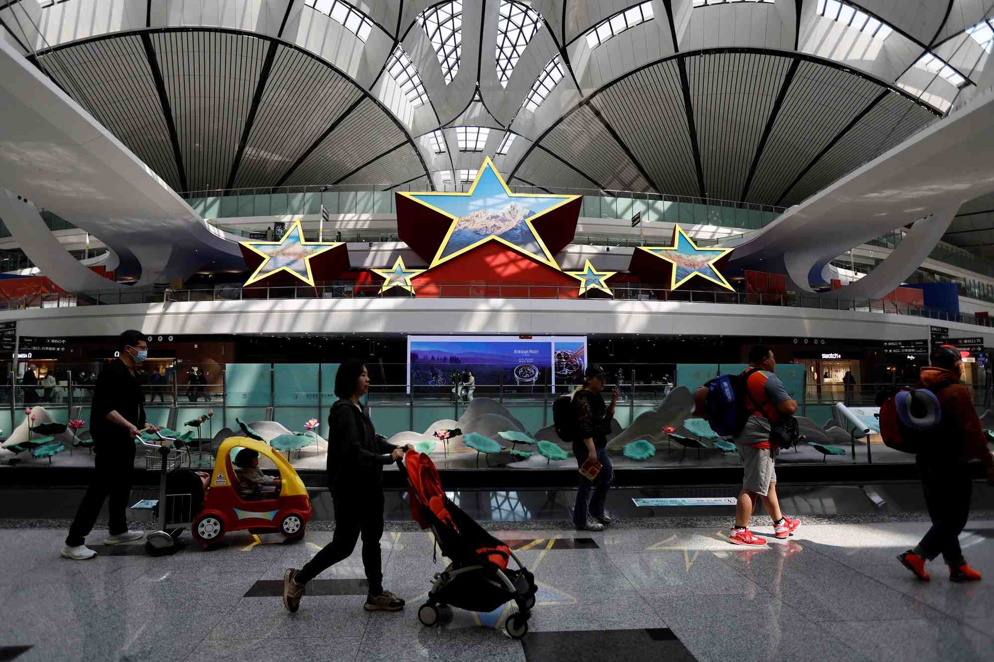 Photo d'archives des  voyageurs qui passent devant une installation en forme de cinq etoiles, a l'aeroport international de pekin daxing a pekin