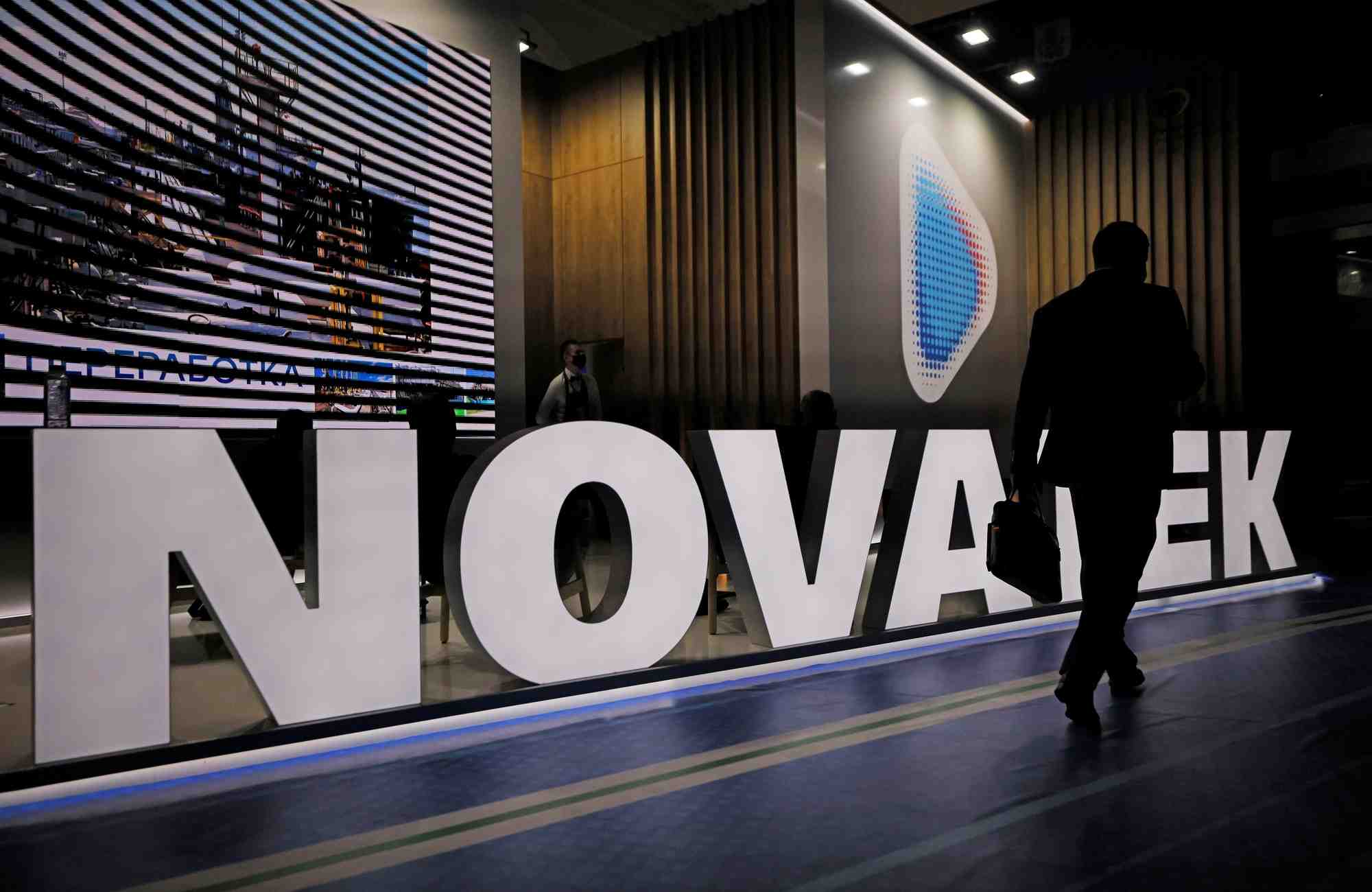 Un participant a un forum passe devant un stand du producteur de gaz russe novatek