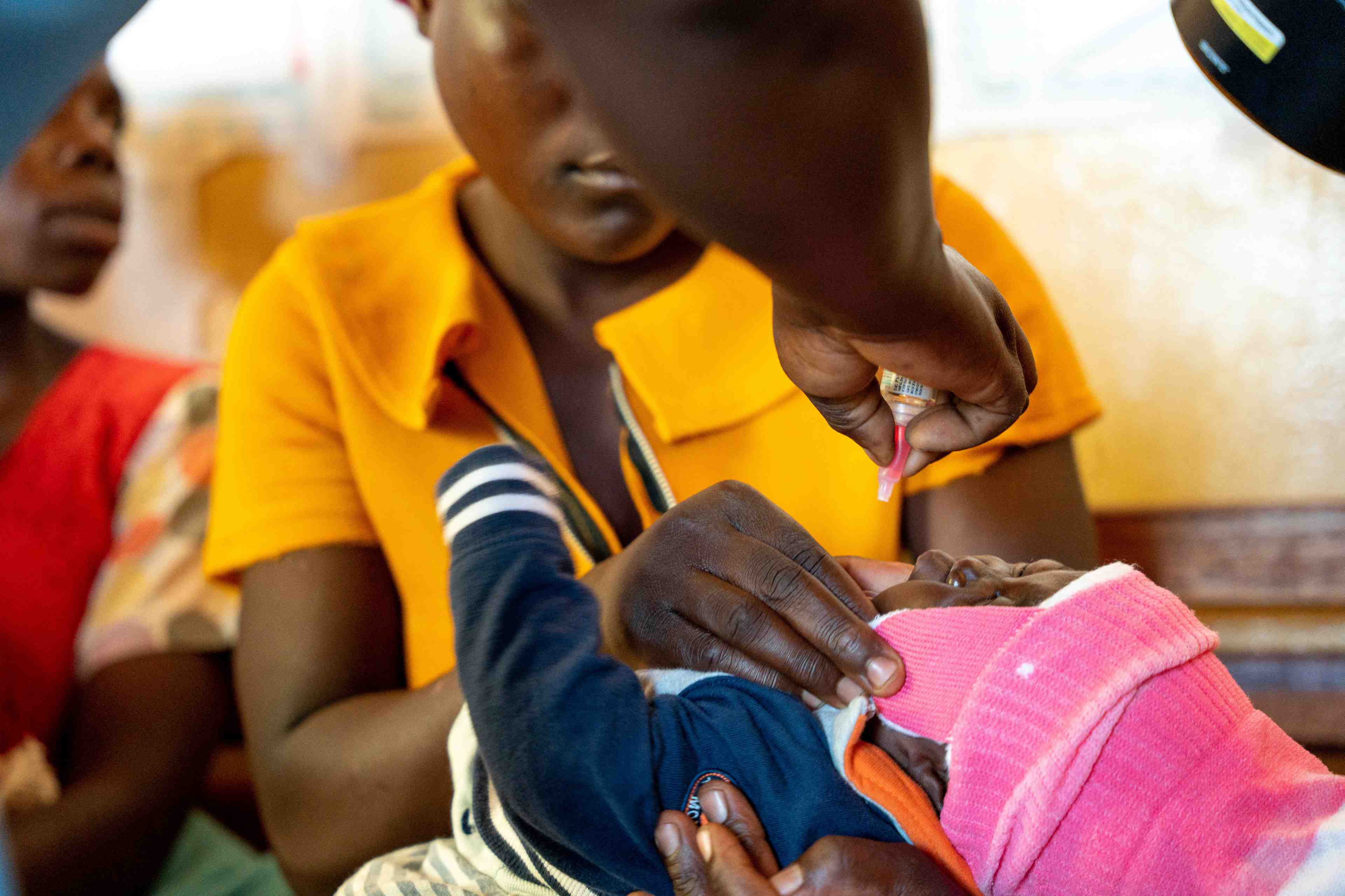 Un enfant recoit un vaccin oral contre le paludisme au centre de sante chileka de lilongwe, au malawi