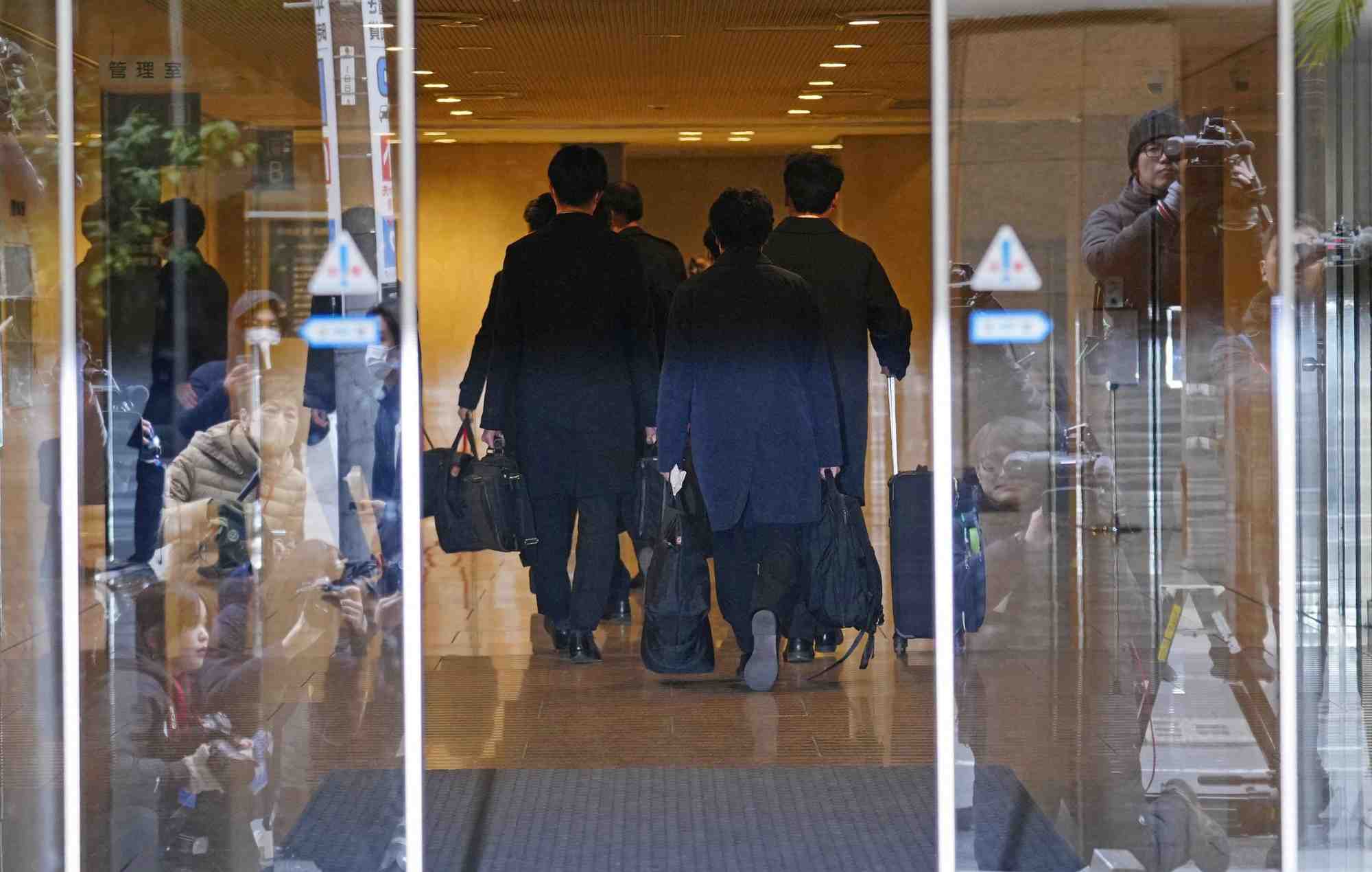 Des membres de l'equipe d'enqueteurs du bureau des procureurs du district de tokyo arrivent pour une perquisition dans un batiment ou se trouve le siege d'une puissante faction politique a tokyo