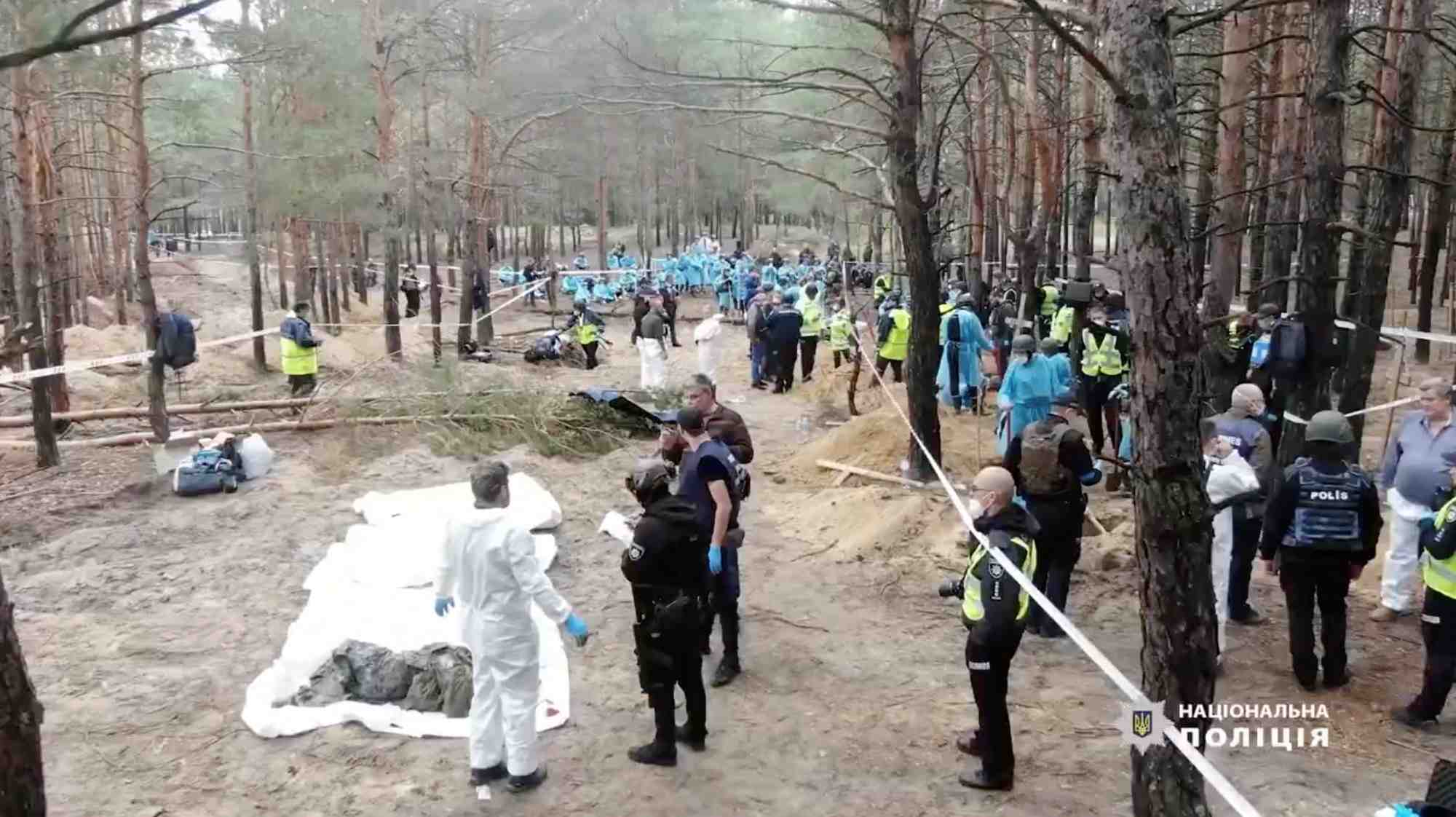 Le personnel medico-legal travaille sur un site d'enterrement collectif pres de la ville d'izium, en ukraine