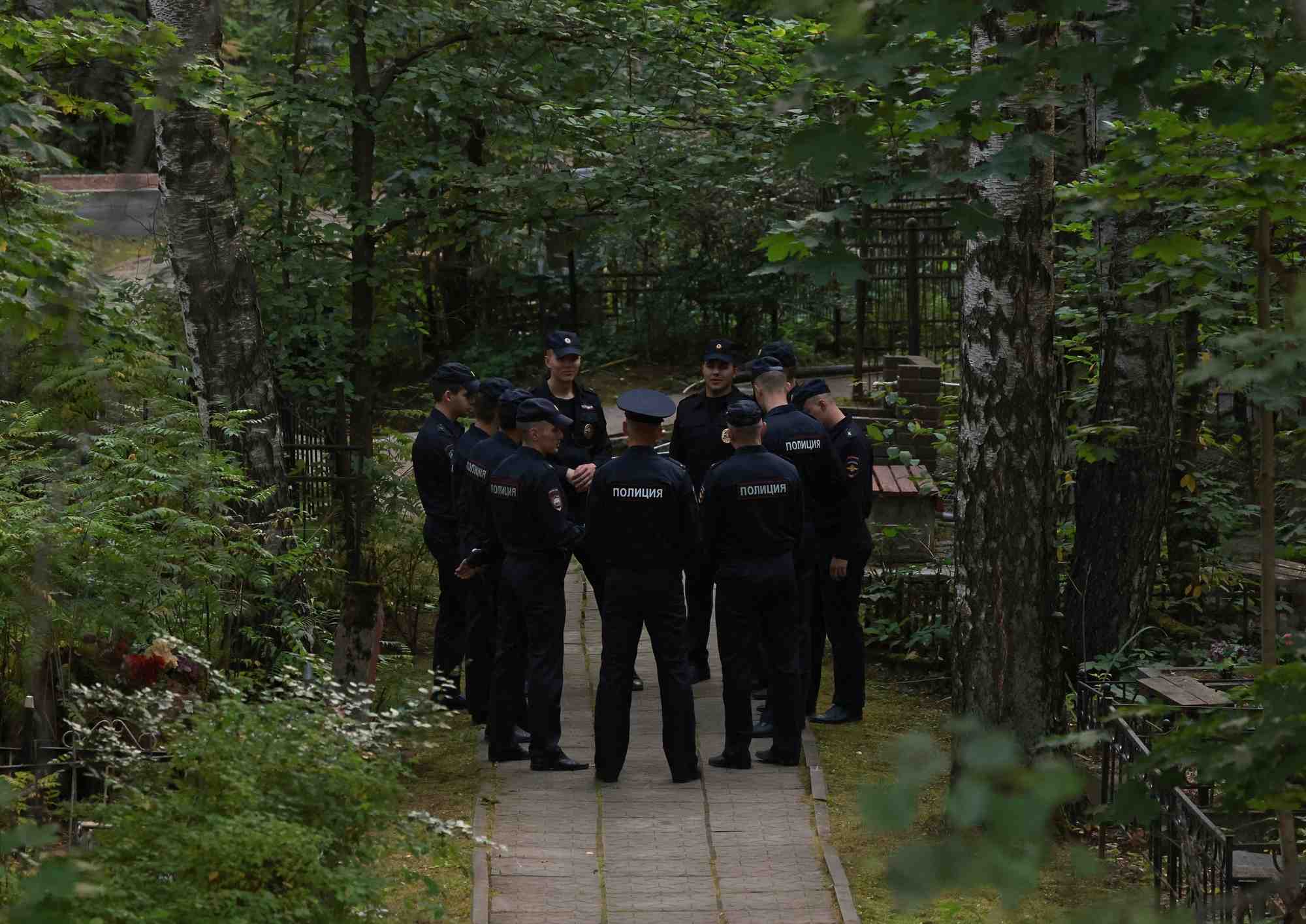 Des policiers se rassemblent pres de la tombe d'evgueni prigojine au cimetiere porokhovskoye a saint-petersbourg