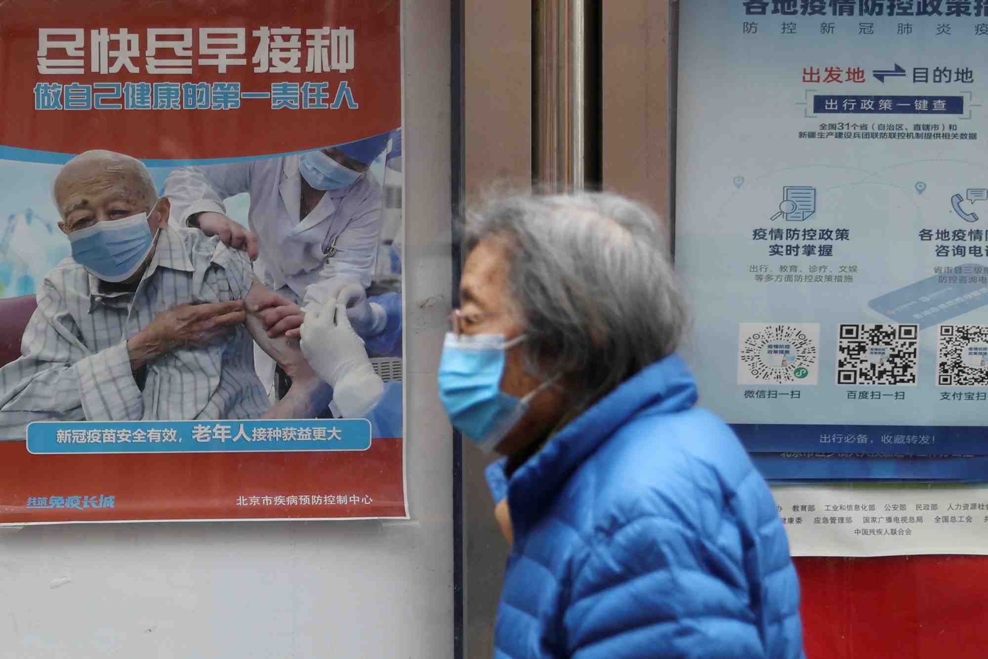 Photo d'archives d'une personne passant devant une affiche pres d'un complexe residentiel a pekin