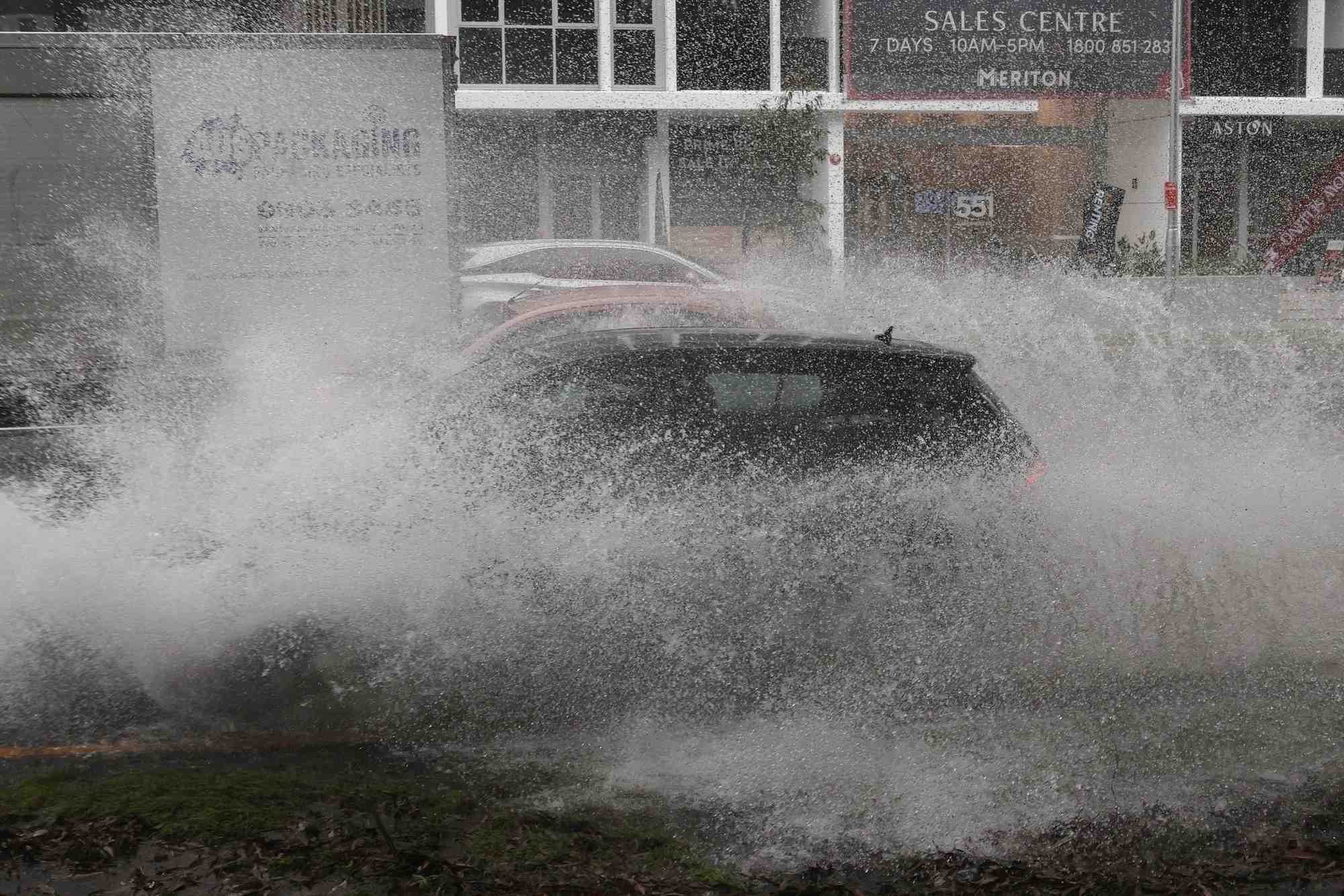 Des vehicules traversent les eaux de crue alors que de fortes pluies affectent sydney, australie