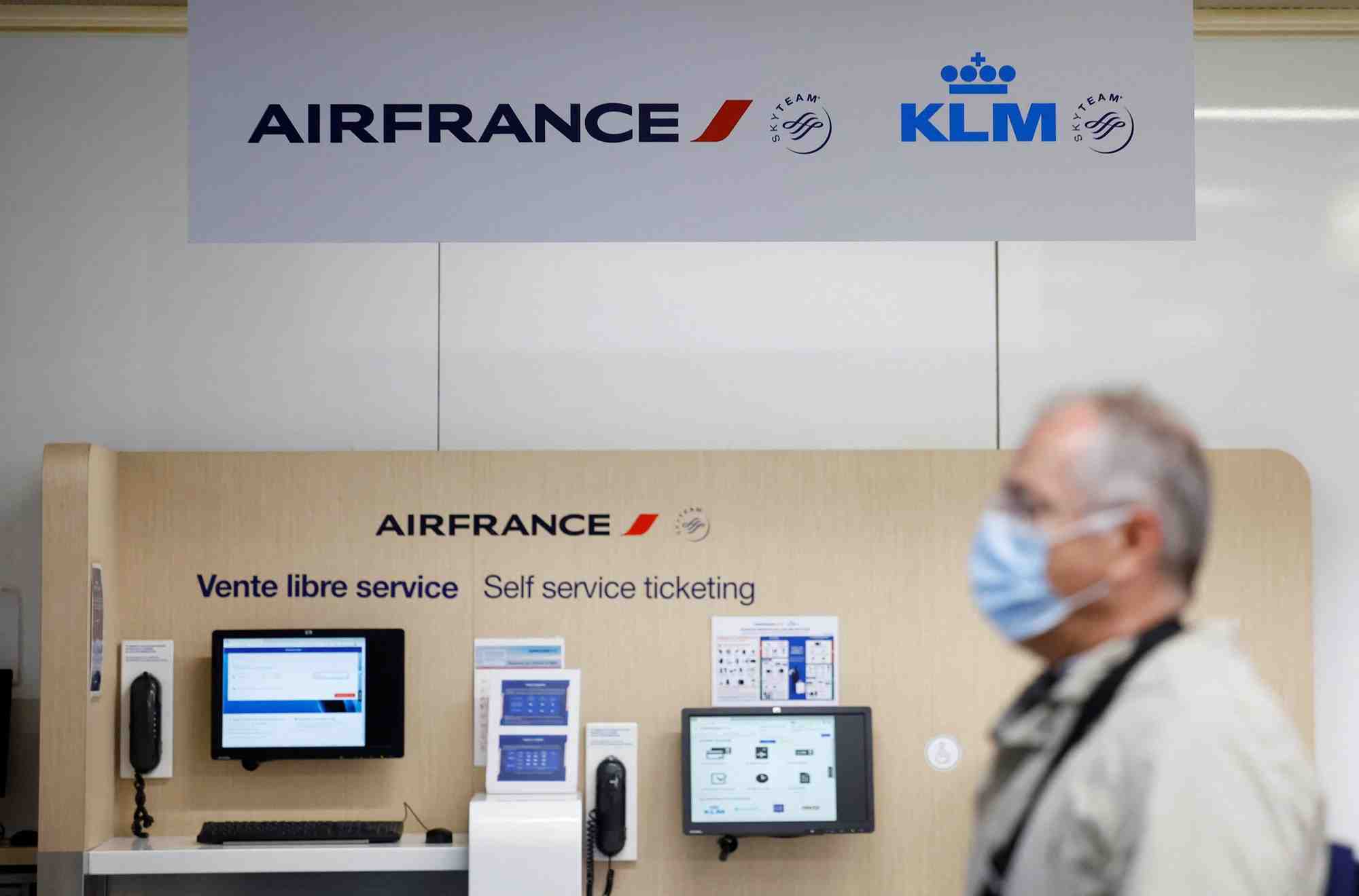 Un passager passe devant les logos air france et klm a l'aeroport de nantes-atlantique en france