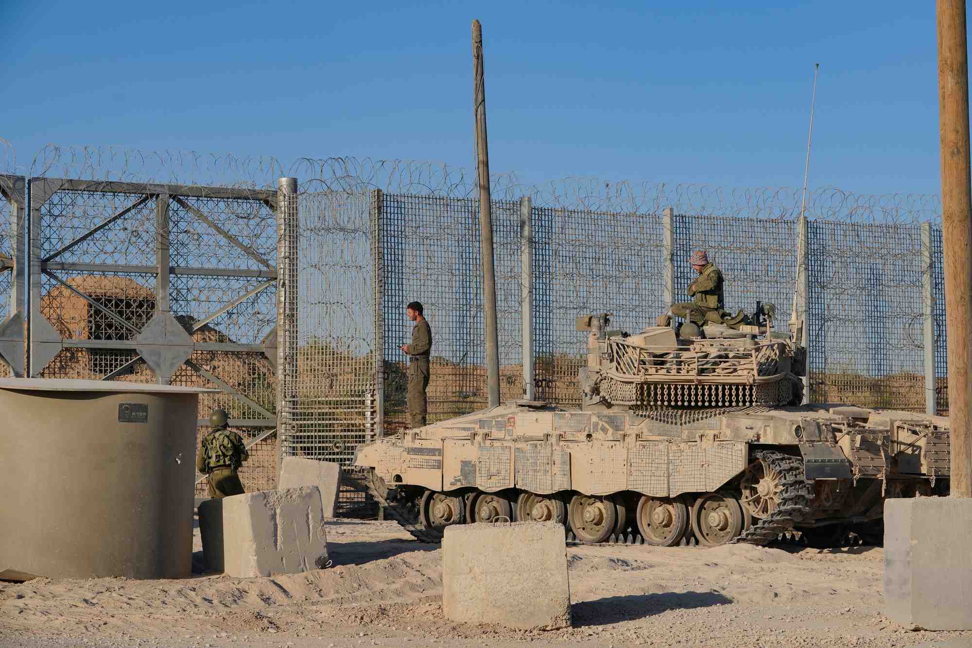 Des soldats israeliens observent depuis le sommet d'un vehicule militaire pres de la frontiere entre israel et gaza