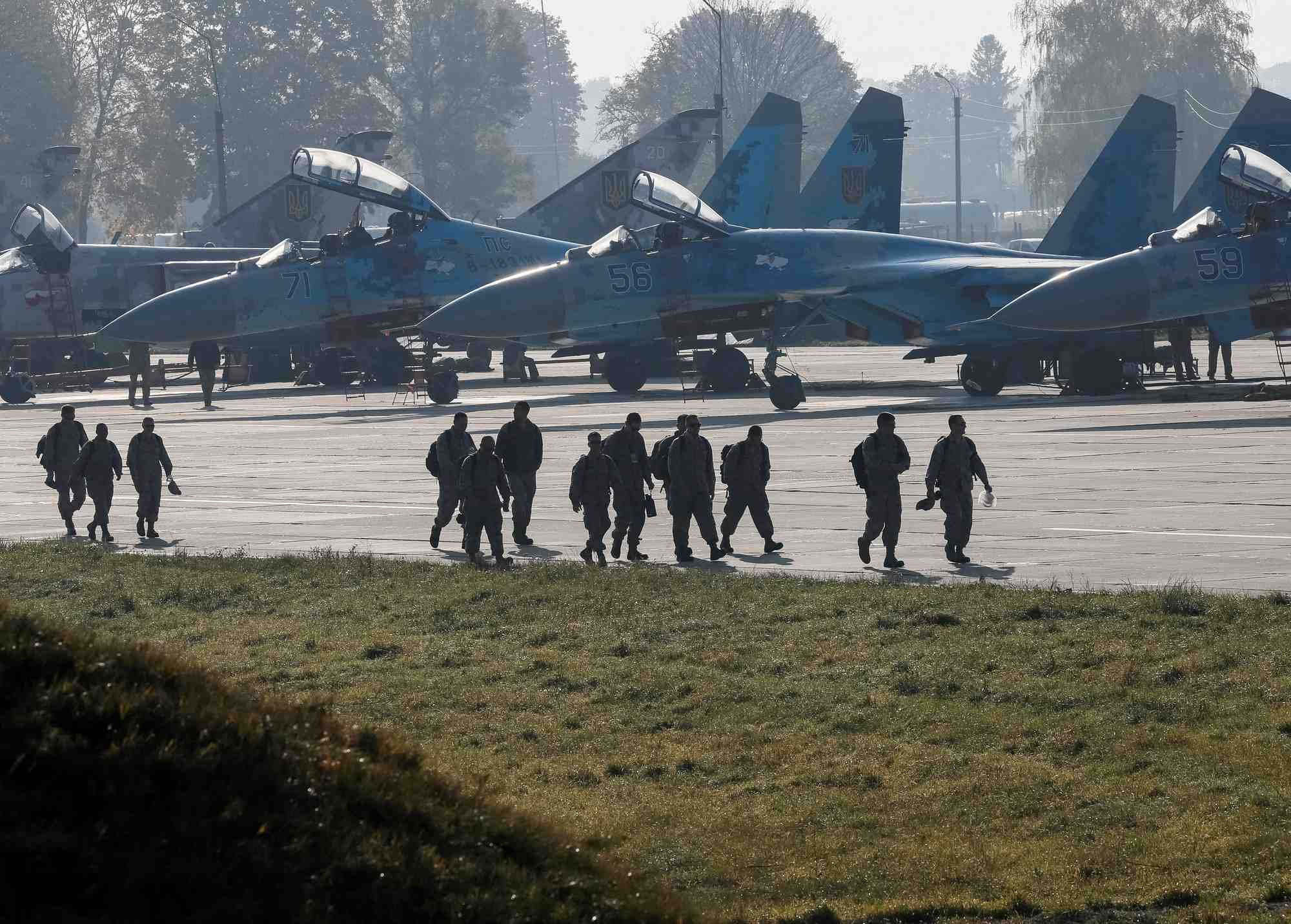 Des soldats americains devant des avions de combat ukrainiens su-27