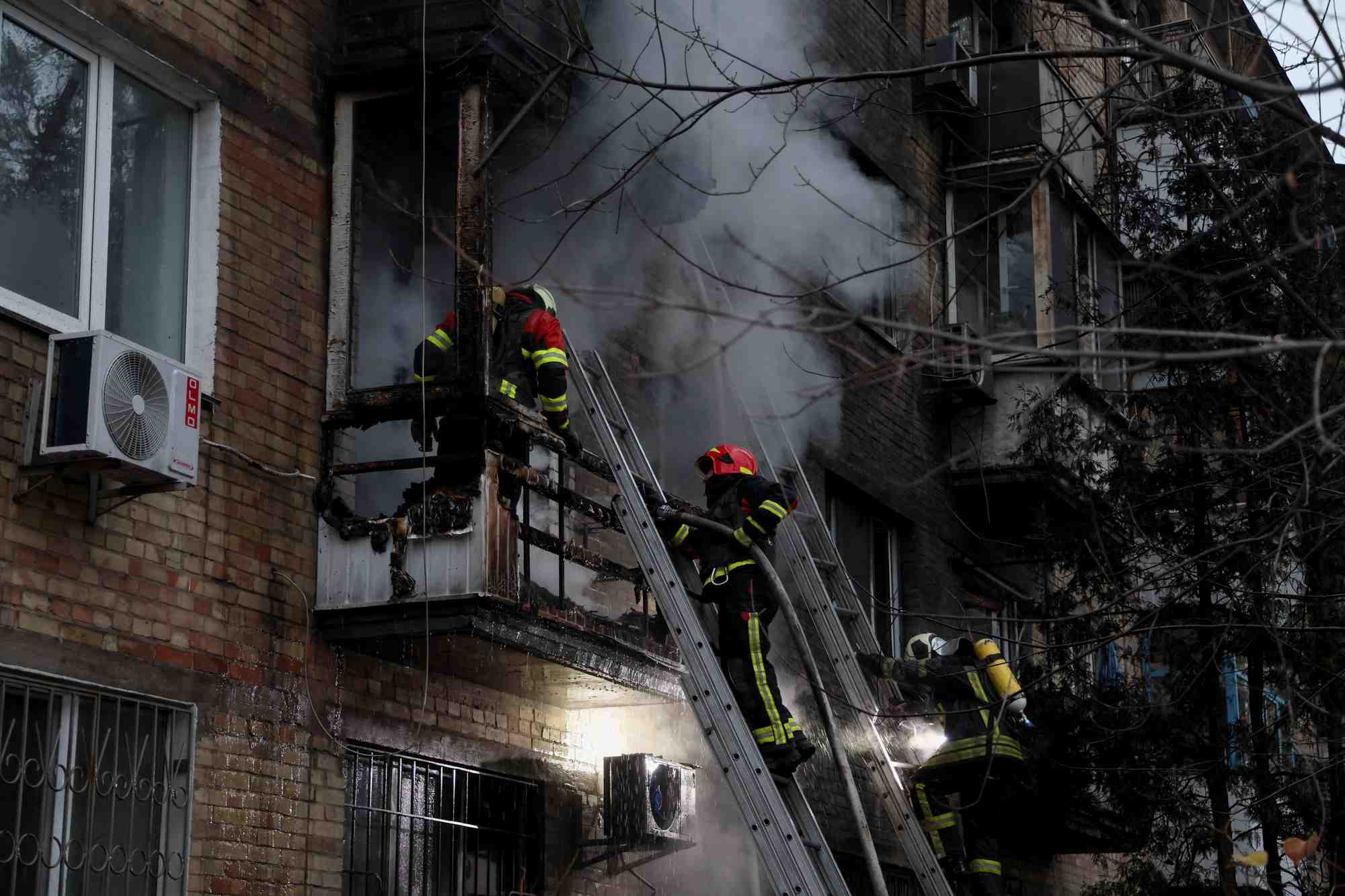 Des pompiers s'efforcent d'eteindre un incendie dans un immeuble residentiel touche par un tir de missile russe a kyiv