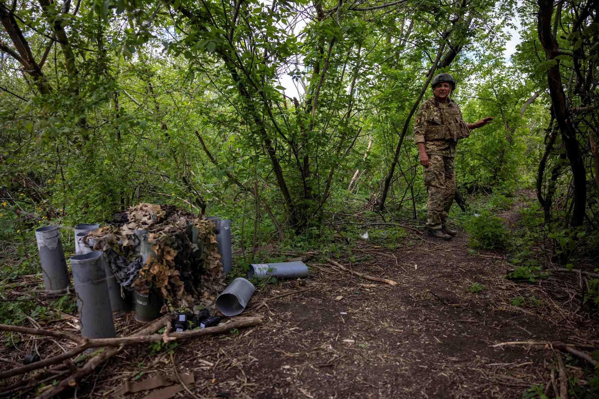 Un soldat ukrainien se tient pres de cartouches d'obus vides a la peripherie de chasiv yar, en ukraine