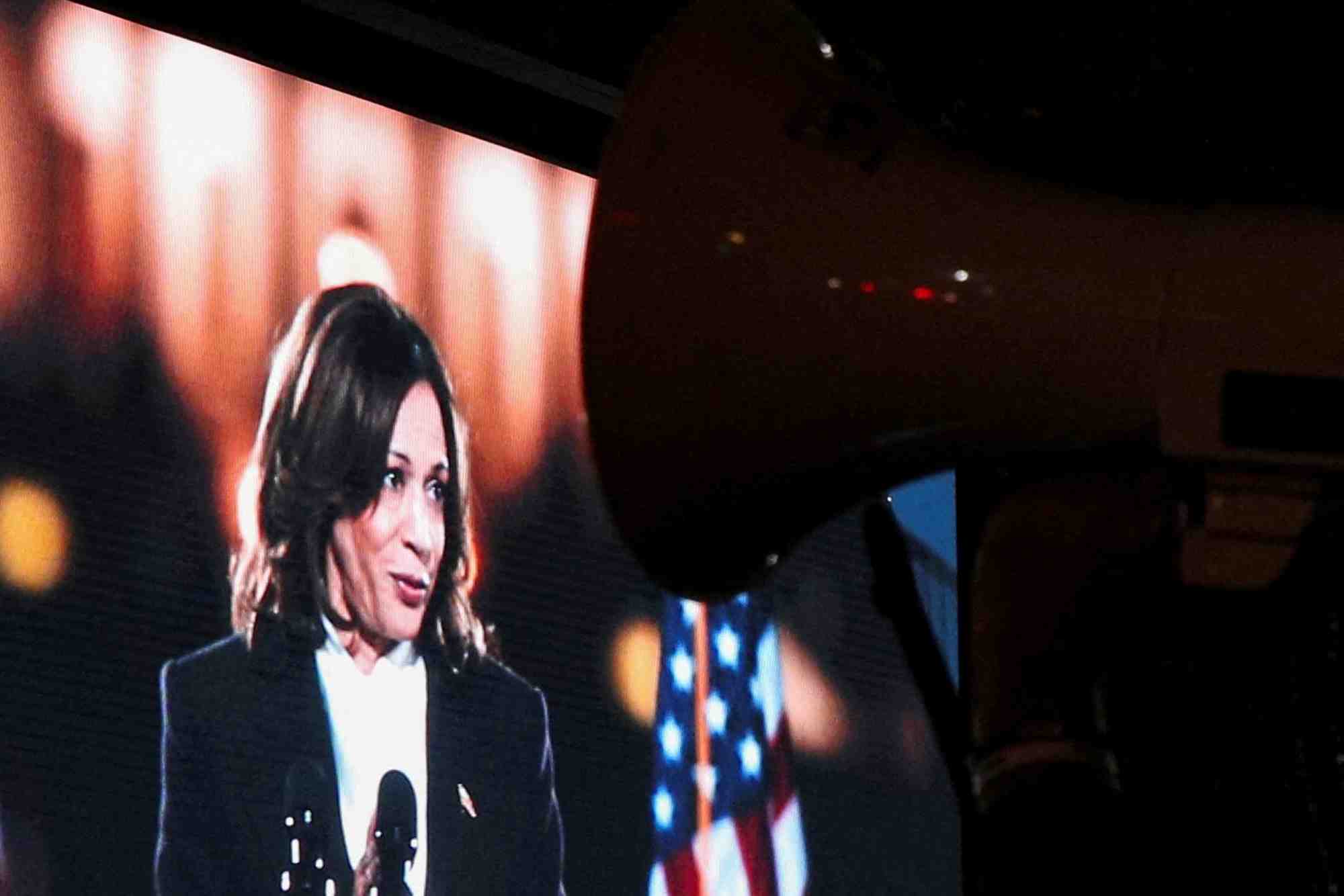 Un ecran affiche kamala harris, prononcant un discours a washington
