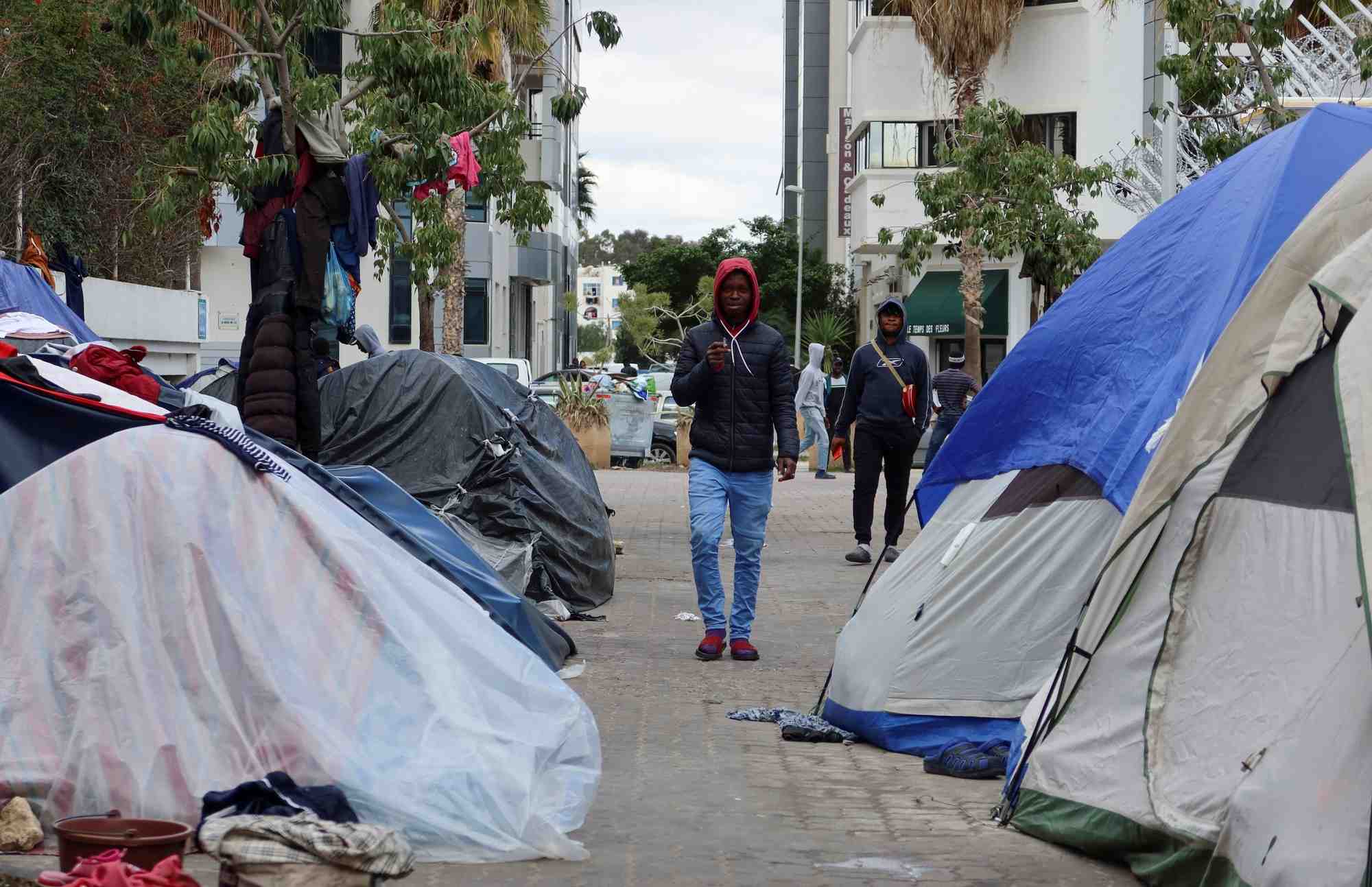 Moumin sou, un migrant malien, marche pres des tentes d'un camp temporaire, a tunis.