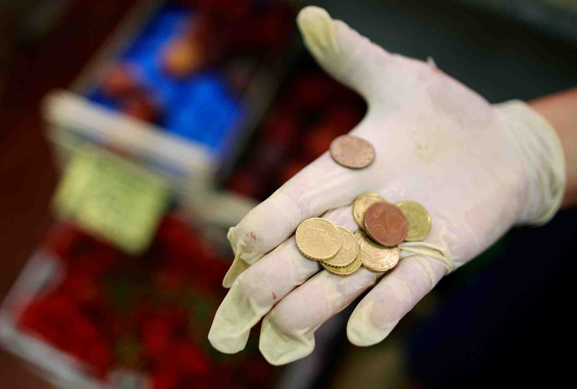 Un vendeur tient des pieces d'euros sur un marche du centre de rome