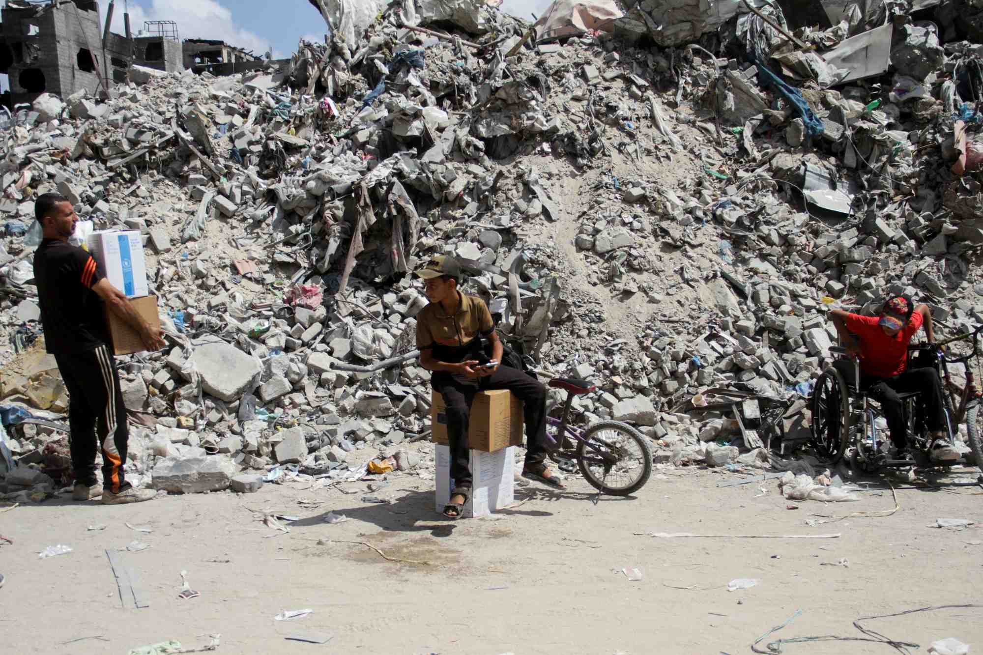 Un garcon est assis sur des boites alors que les palestiniens se rassemblent pour obtenir de l'aide a jabalia, dans le nord de la bande de gaza