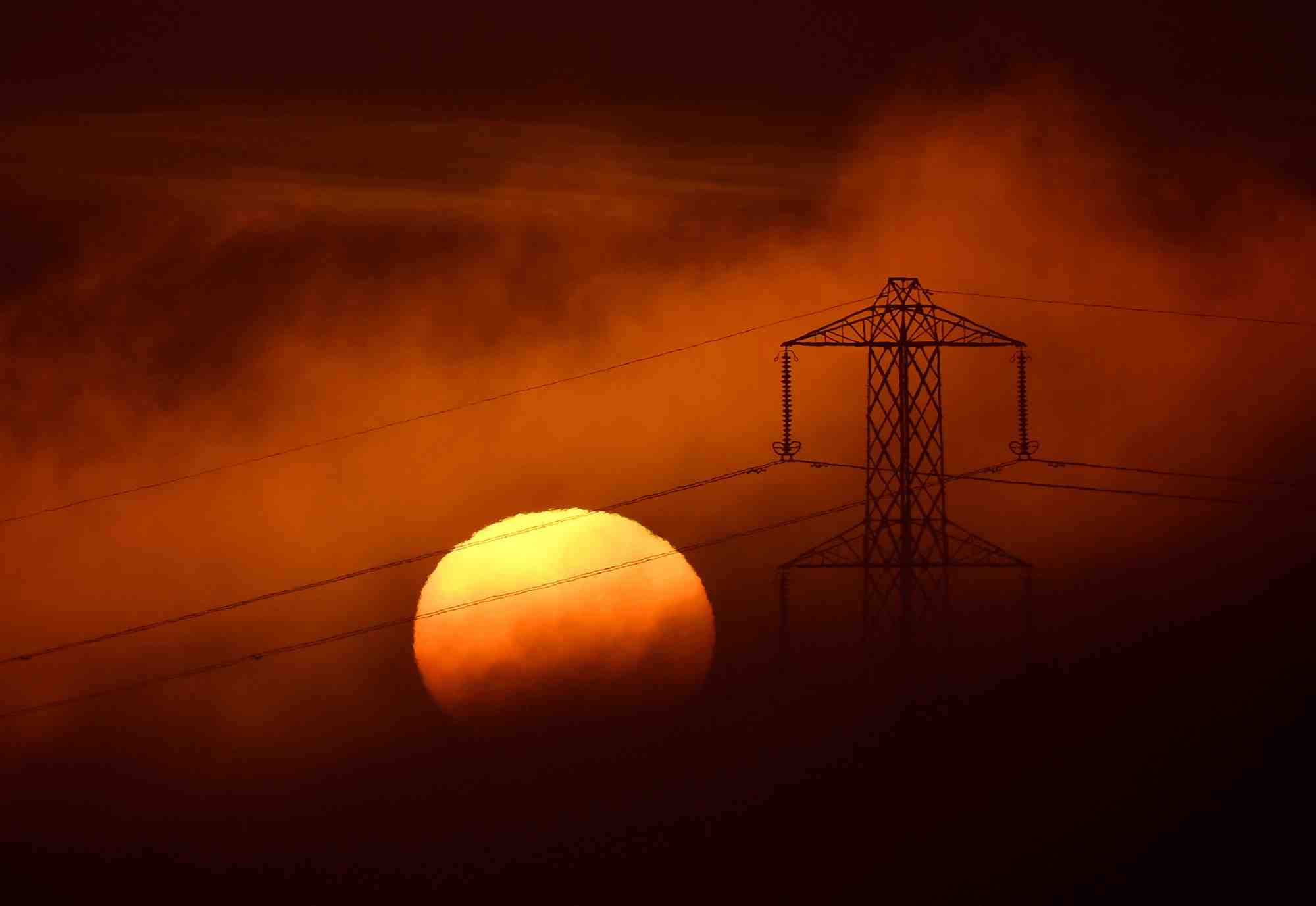 Le soleil se couche derriere un pylone electrique pres de petersfield, en grande-bretagne