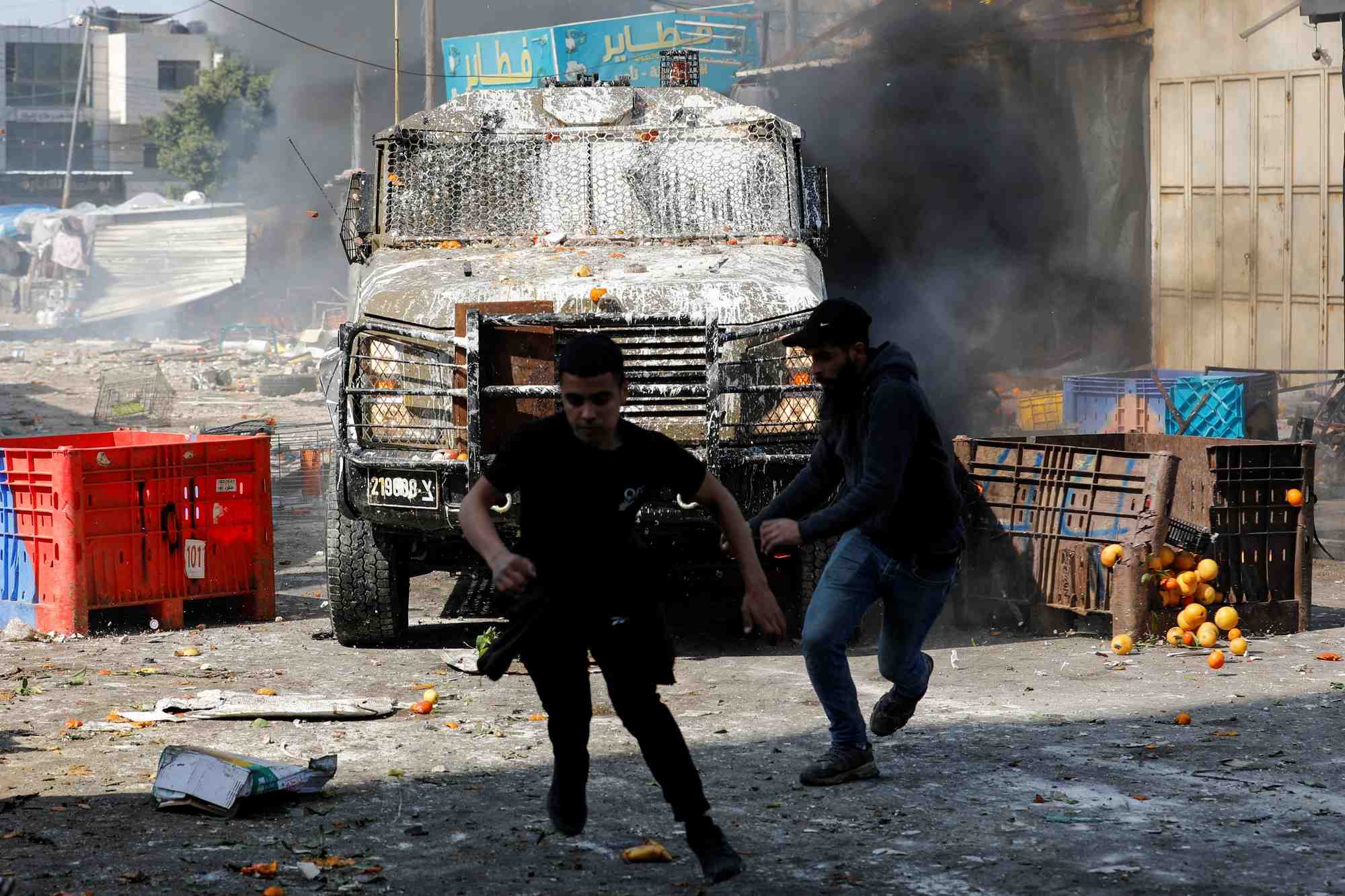 Des palestiniens courent alors qu'ils affrontent les forces israeliennes en cisjordanie occupee par israel