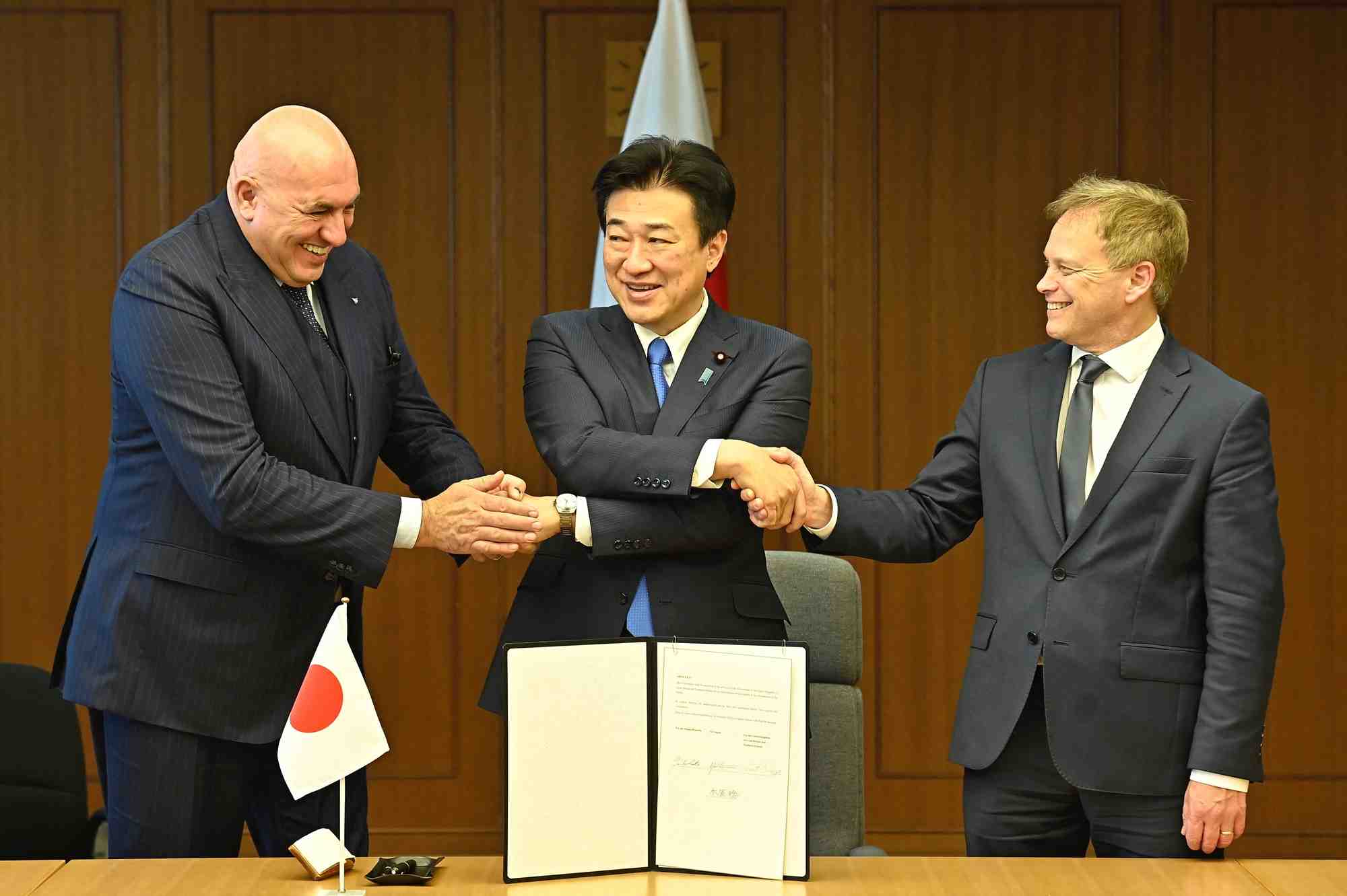 Les ministres britannique de la defense de grand-bretagne, d'italie et du japon se serrent la main