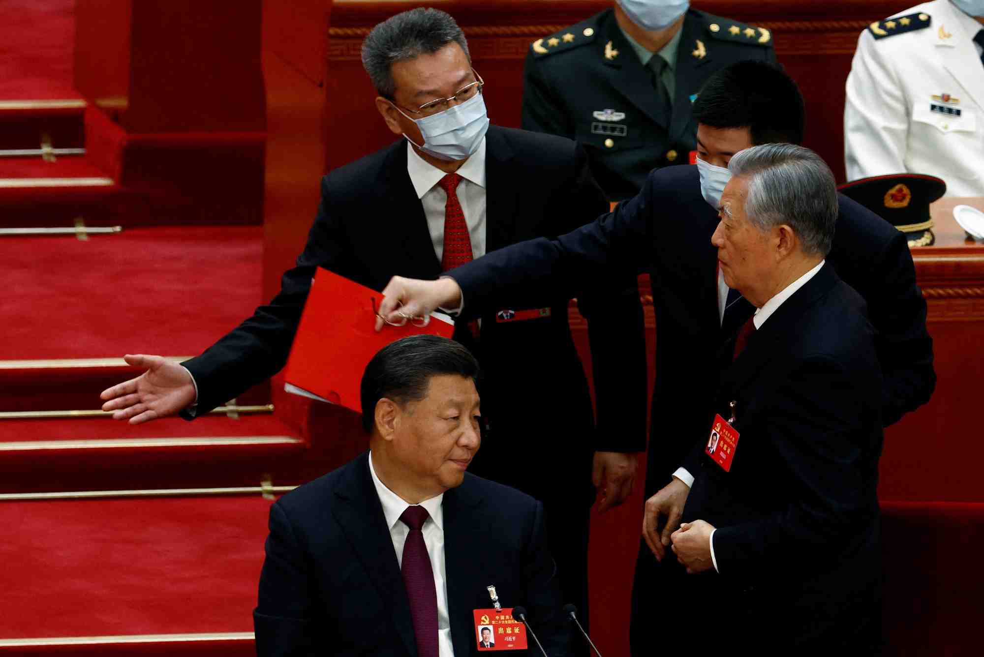 Hu jintao quitte son siege aux cotes du president chinois xi jinping lors de la ceremonie de cloture du 20e congres national du parti communiste chinois