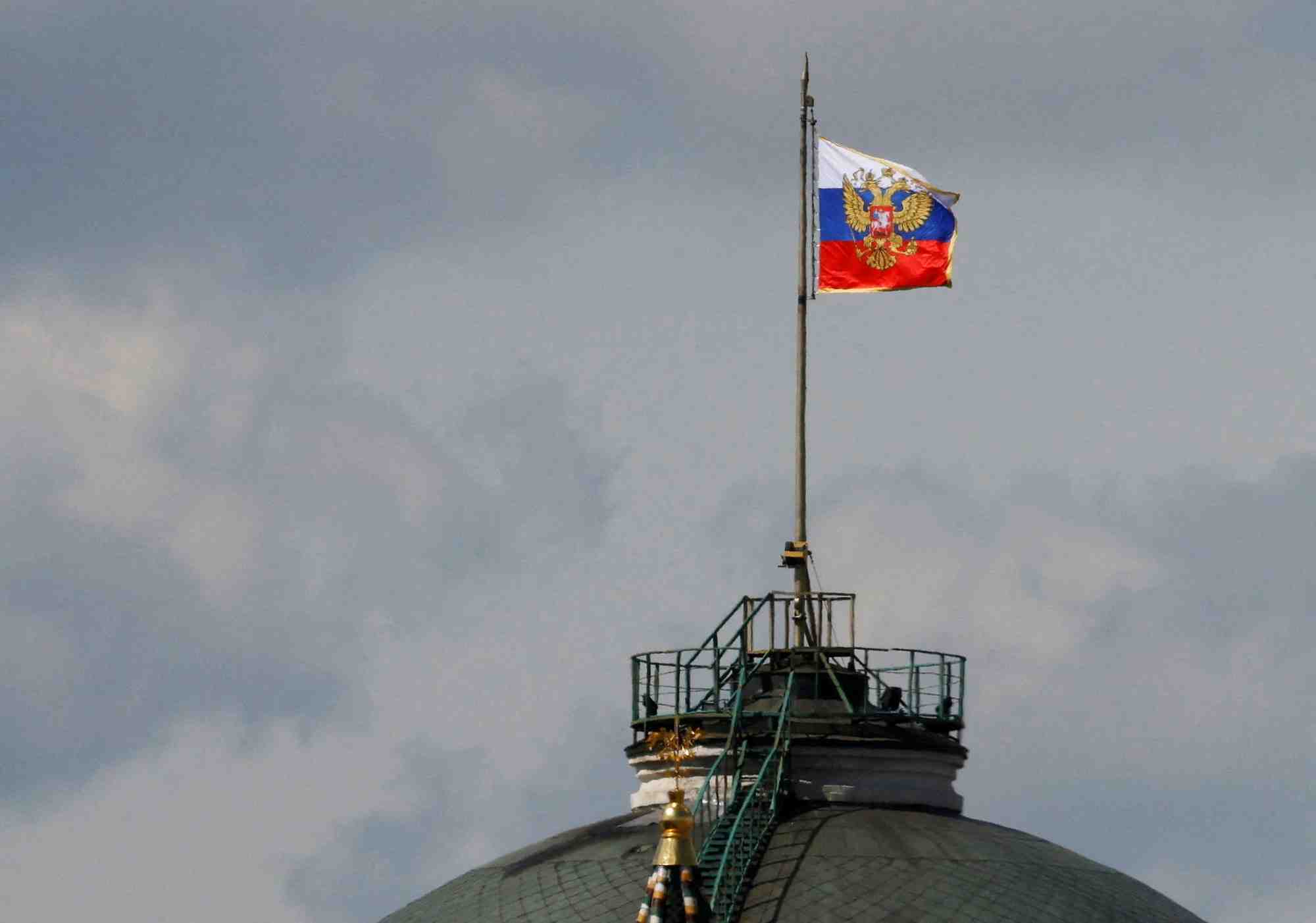 Le drapeau russe flotte sur le dome du batiment du senat du kremlin a moscou