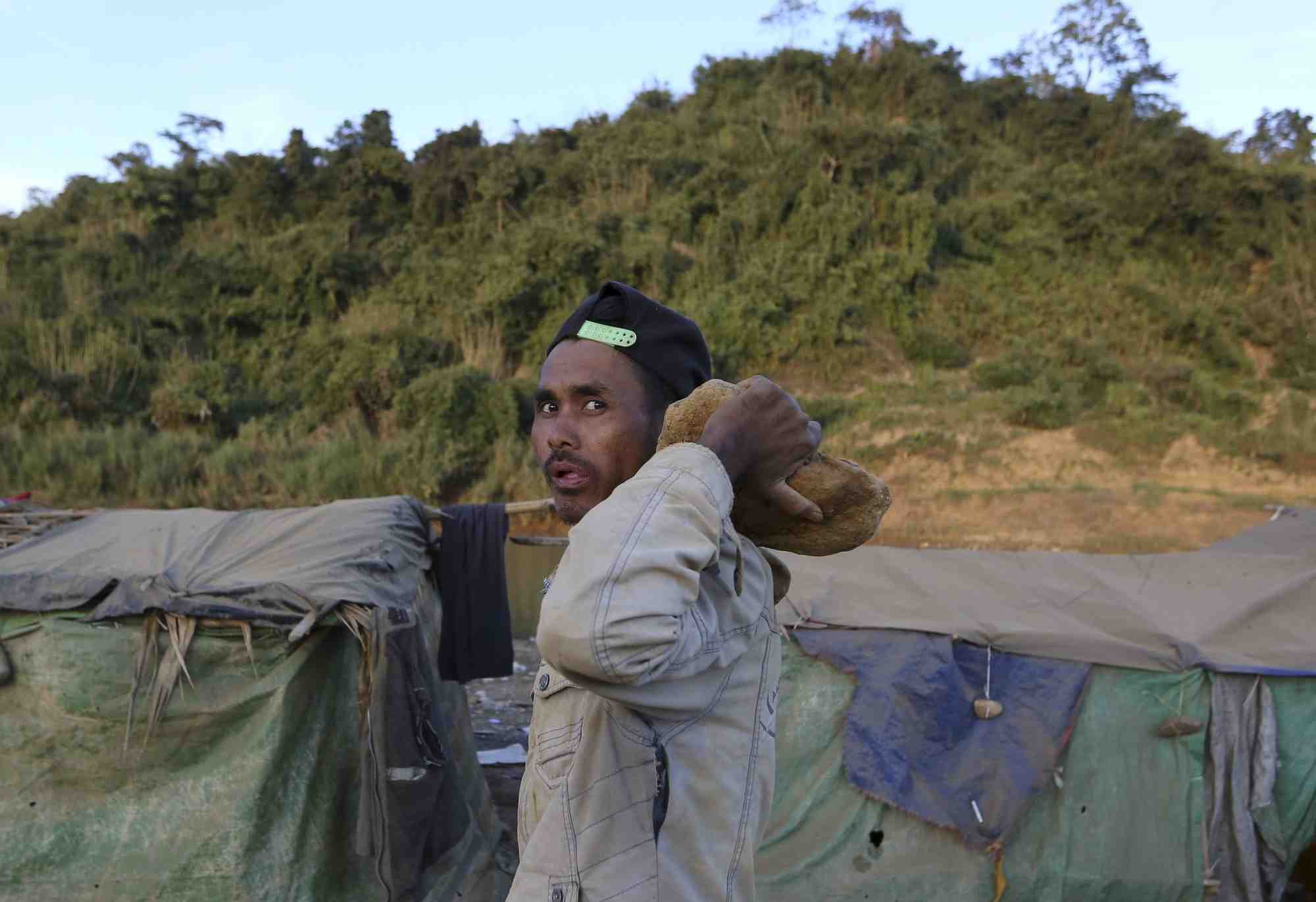 Un mineur au cote d'un mine de jade a hpakant, au myanmar