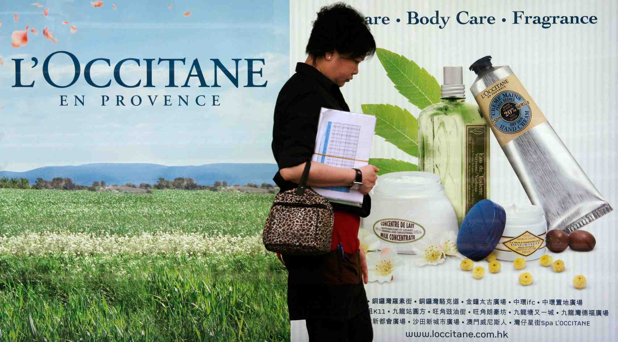 Une femme passe devant une publicite de l'occitane a hong kong. /photo prise le 19 avril 2010/reuters/bobby yip