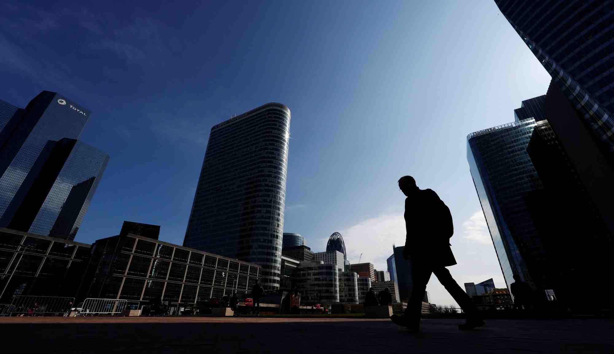 Des personnes marchent sur l'esplanade de la defense, a l'ouest de paris