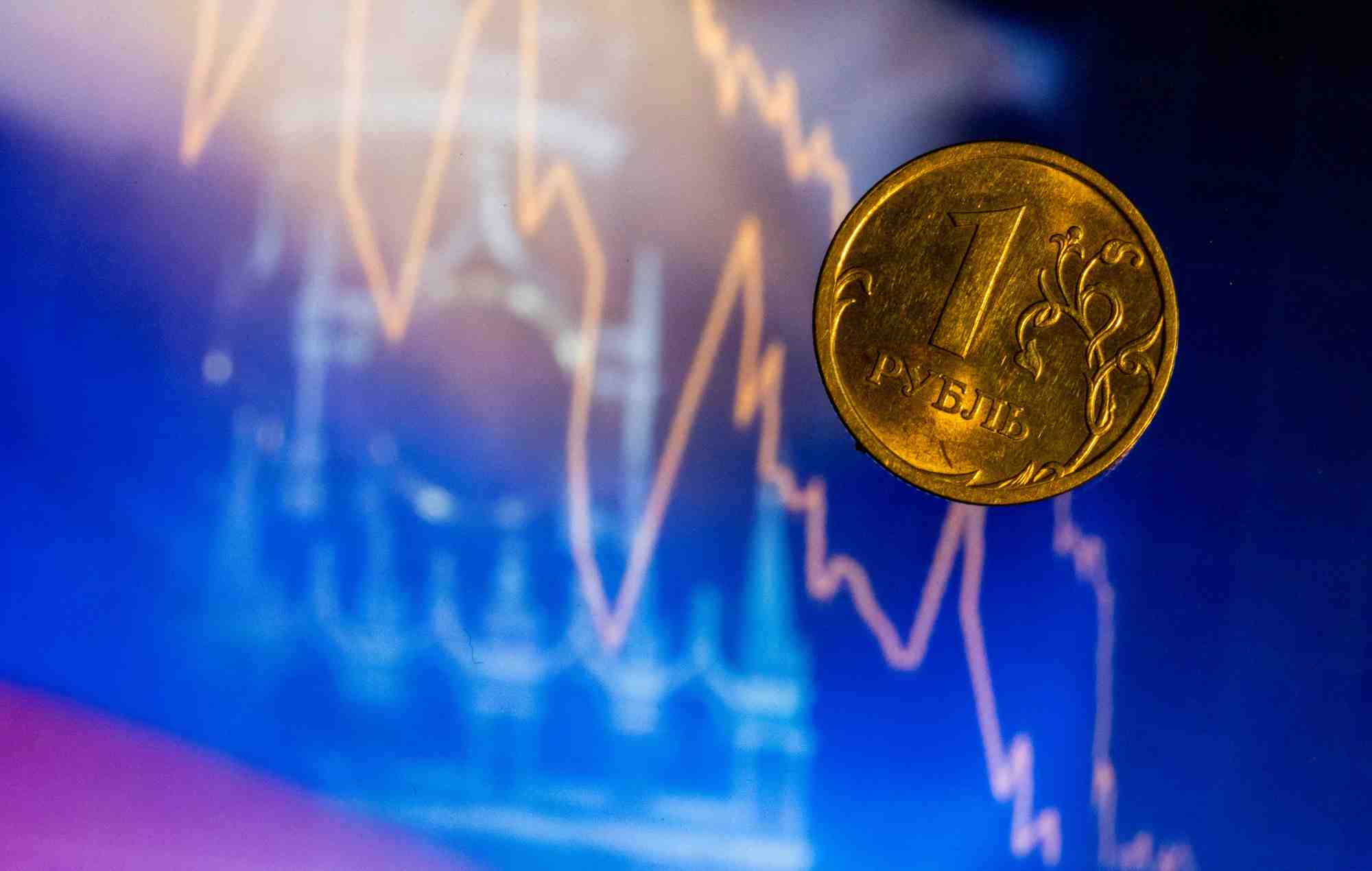 Piece d'un rouble russe devant un ecran affichant la tour spasskaya du kremlin a moscou