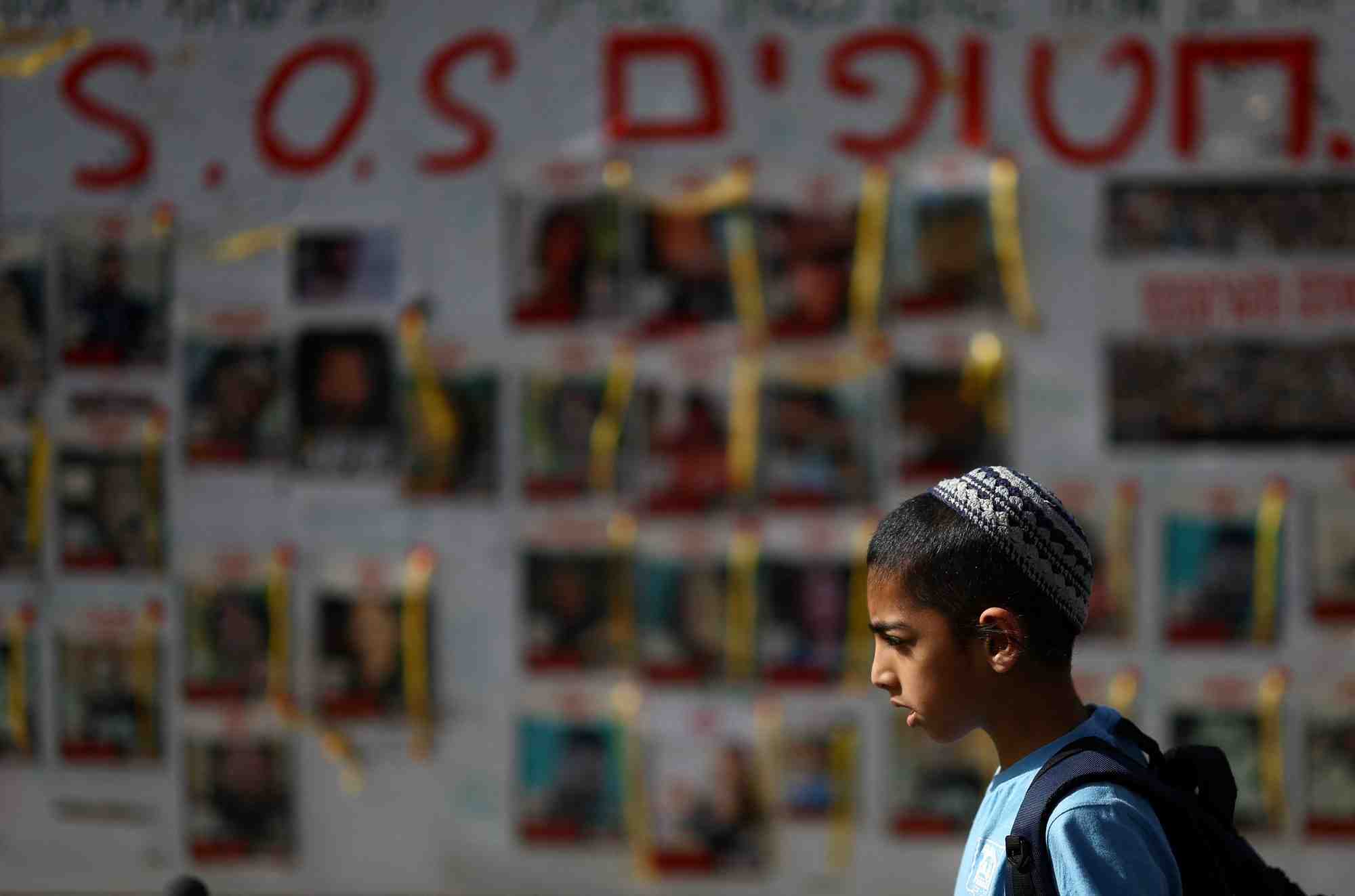 Des personnes passent devant des affiches montrant des photos d'otages enleves lors de l'attaque du 7 octobre par le hamas, a tel aviv