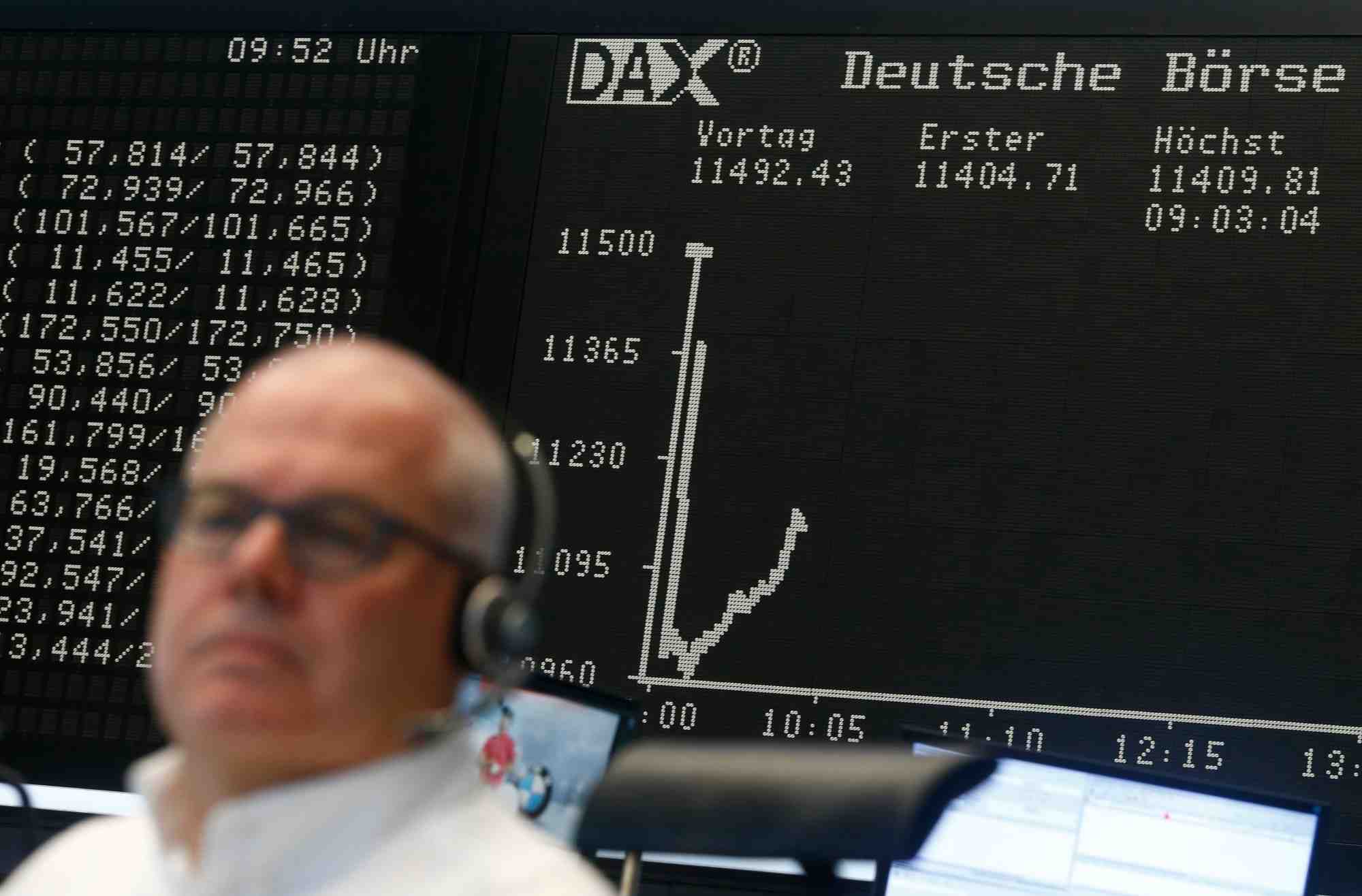 Un trader est assis devant le tableau du dax a son bureau a la bourse de francfort