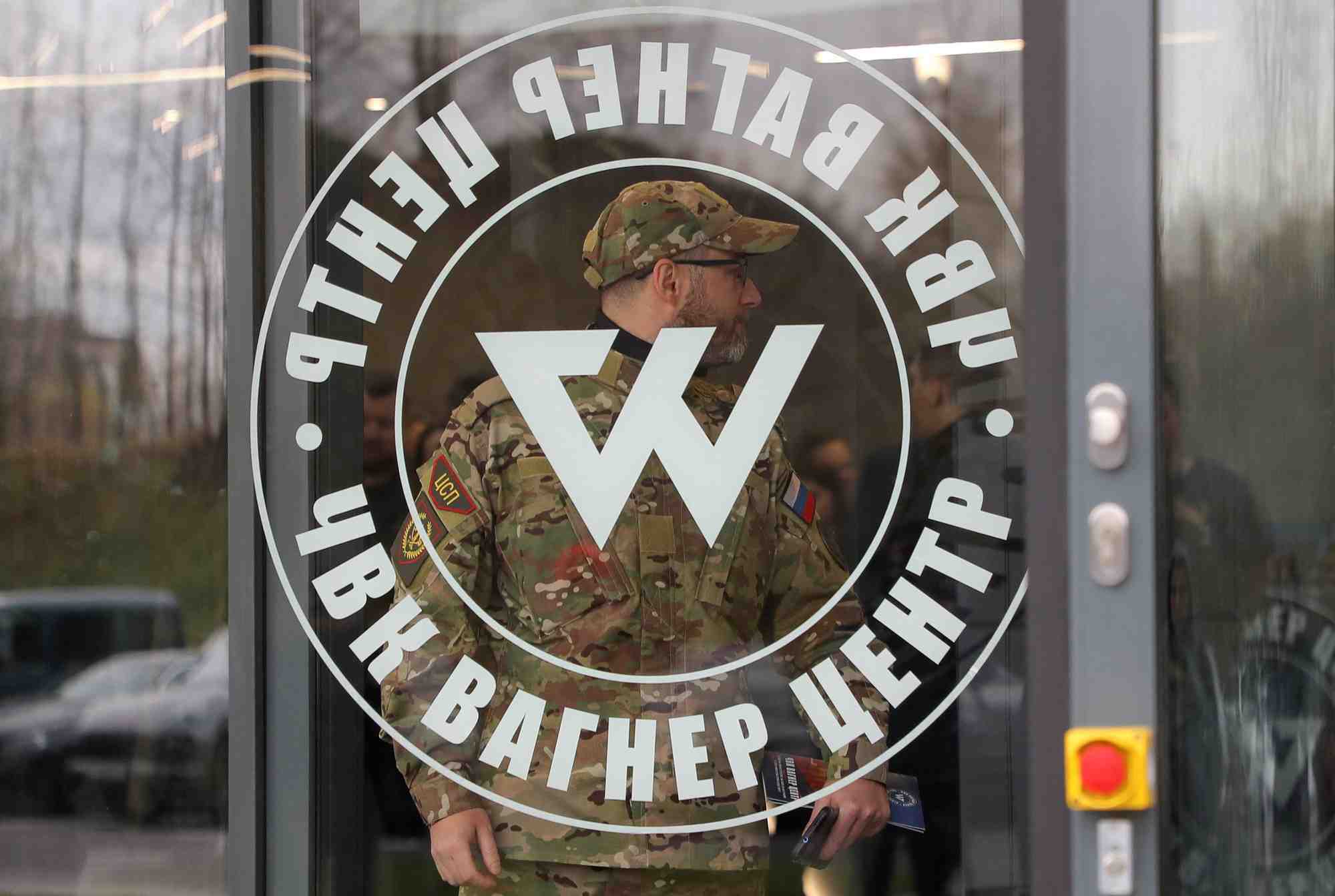 Un homme portant un uniforme de camouflage sort du centre pmc wagner a saint-petersbourg