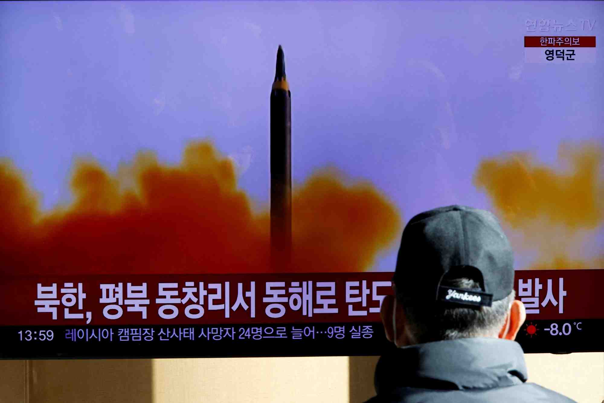 Un homme regardant le bulletin d'information sur le tir d'un missile balistique par la coree du nord