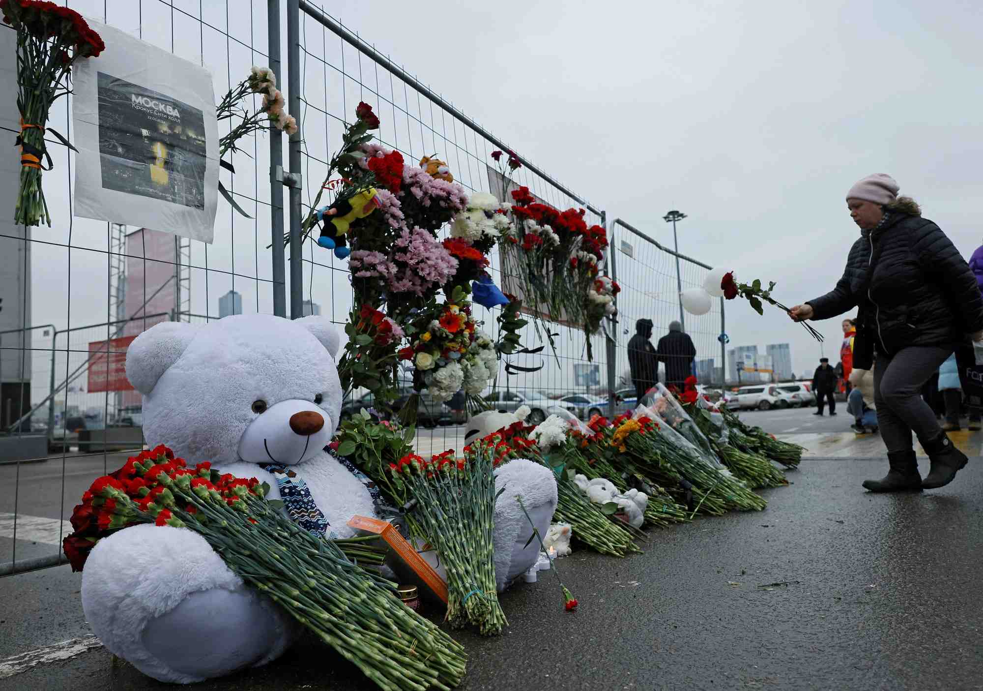Une femme depose des fleurs sur un memorial improvise en l'honneur des victimes d'un attentat a la salle de concert crocus city hall, dans la banlieue de moscou