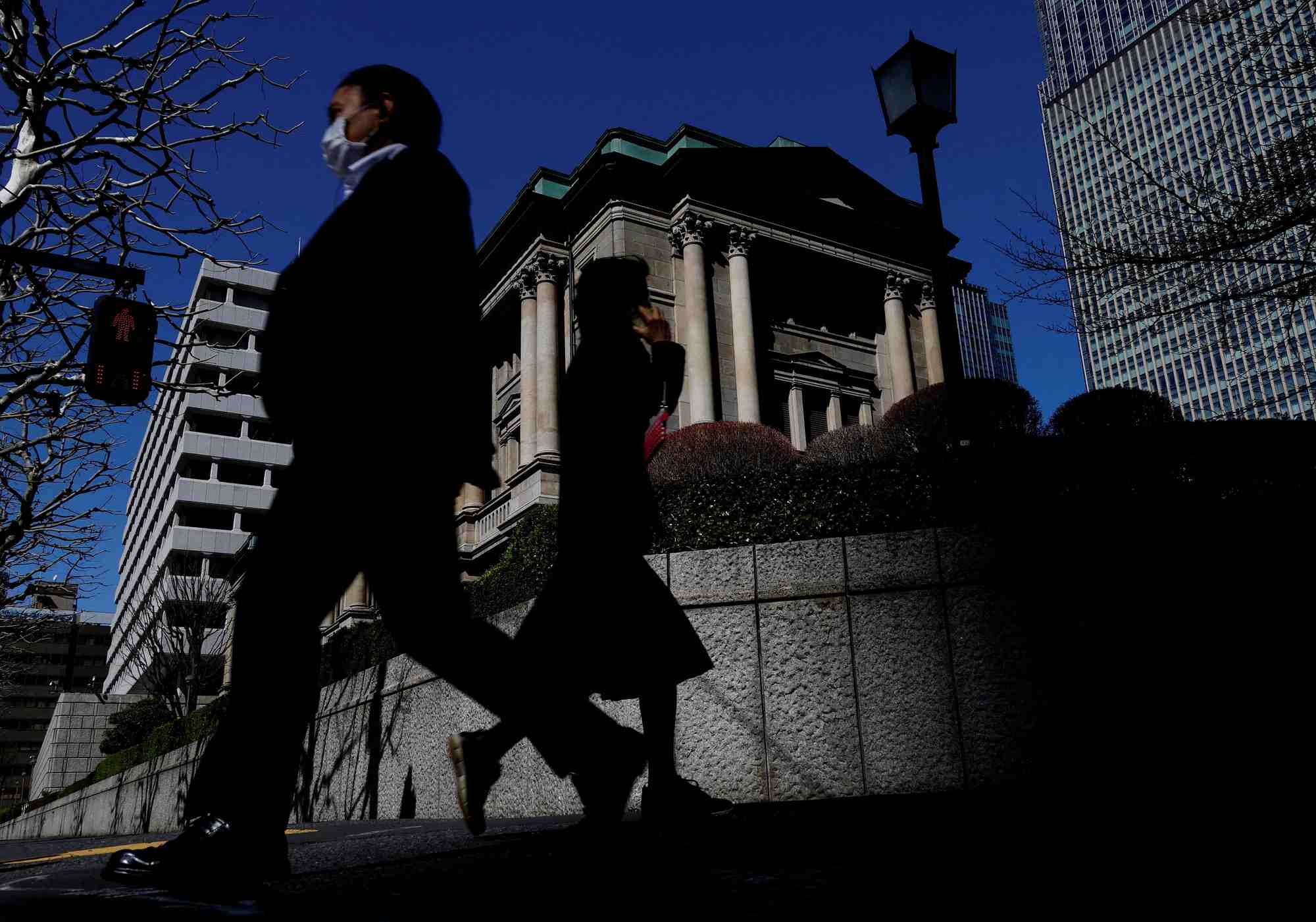 Des pietons passent devant le batiment de la banque du japon a tokyo