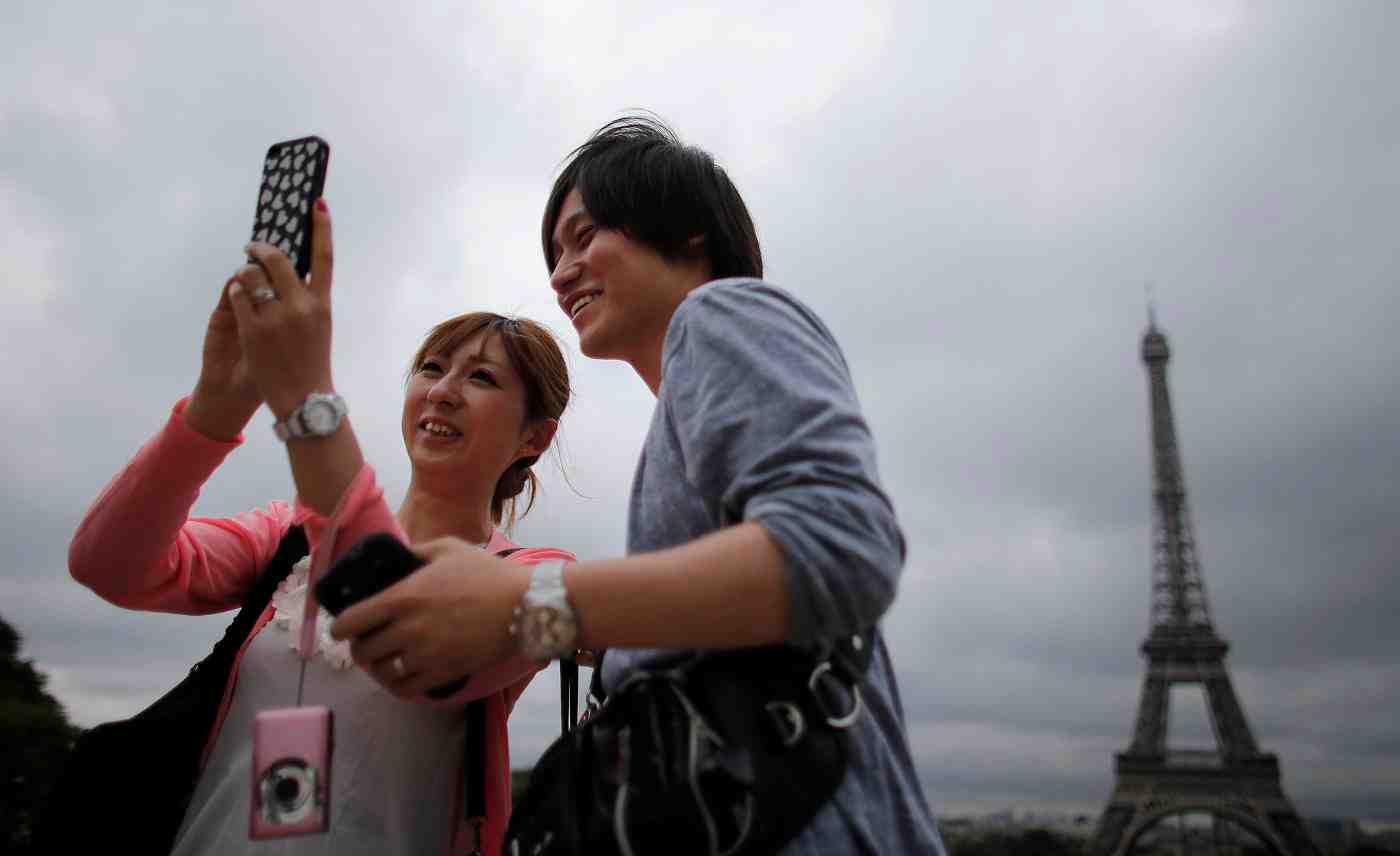 Touristes asiatiques à Paris devant la Tour Eiffel