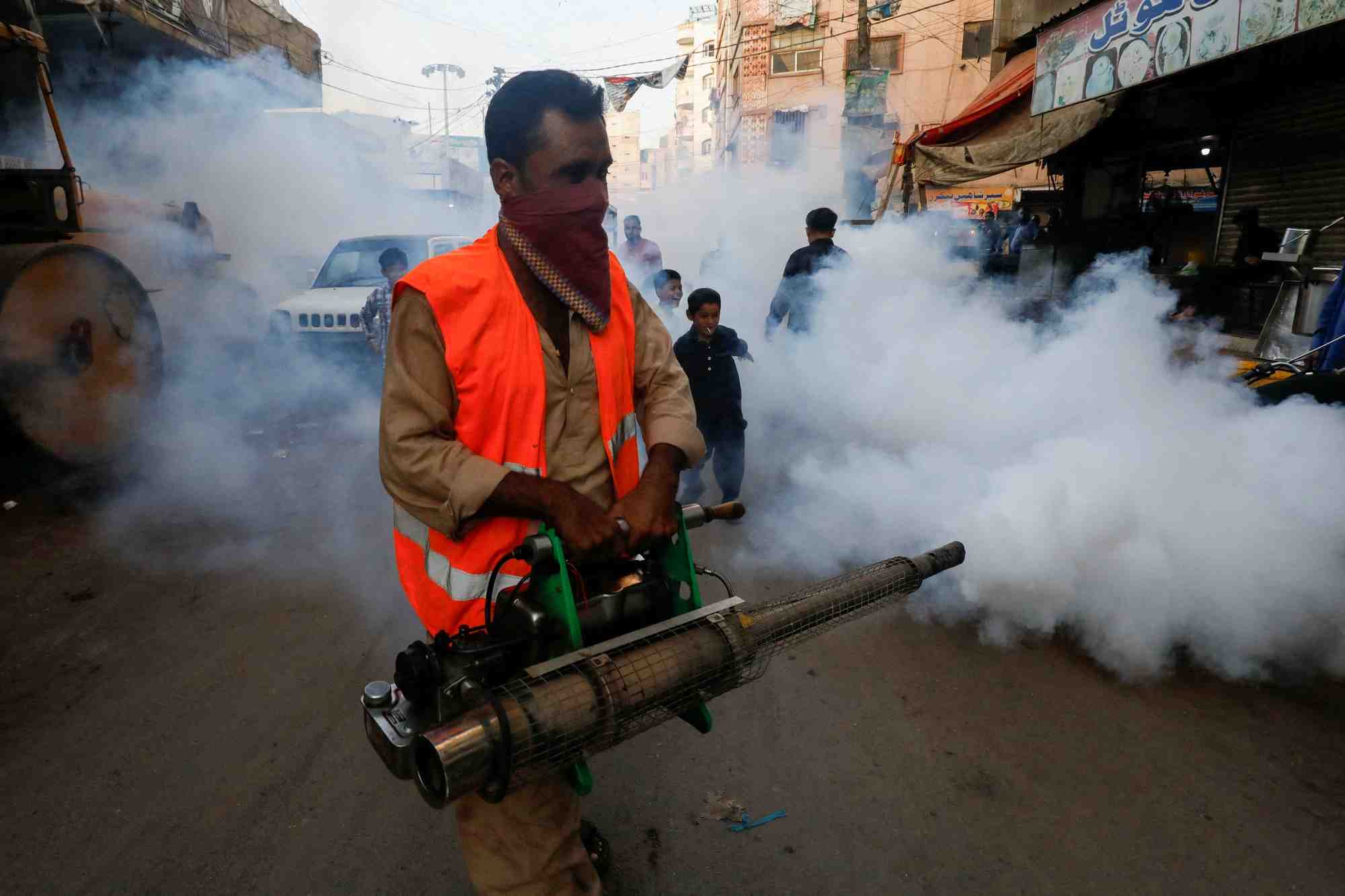 Un homme vaporise un insecticide dans une rue de karachi, au pakistan