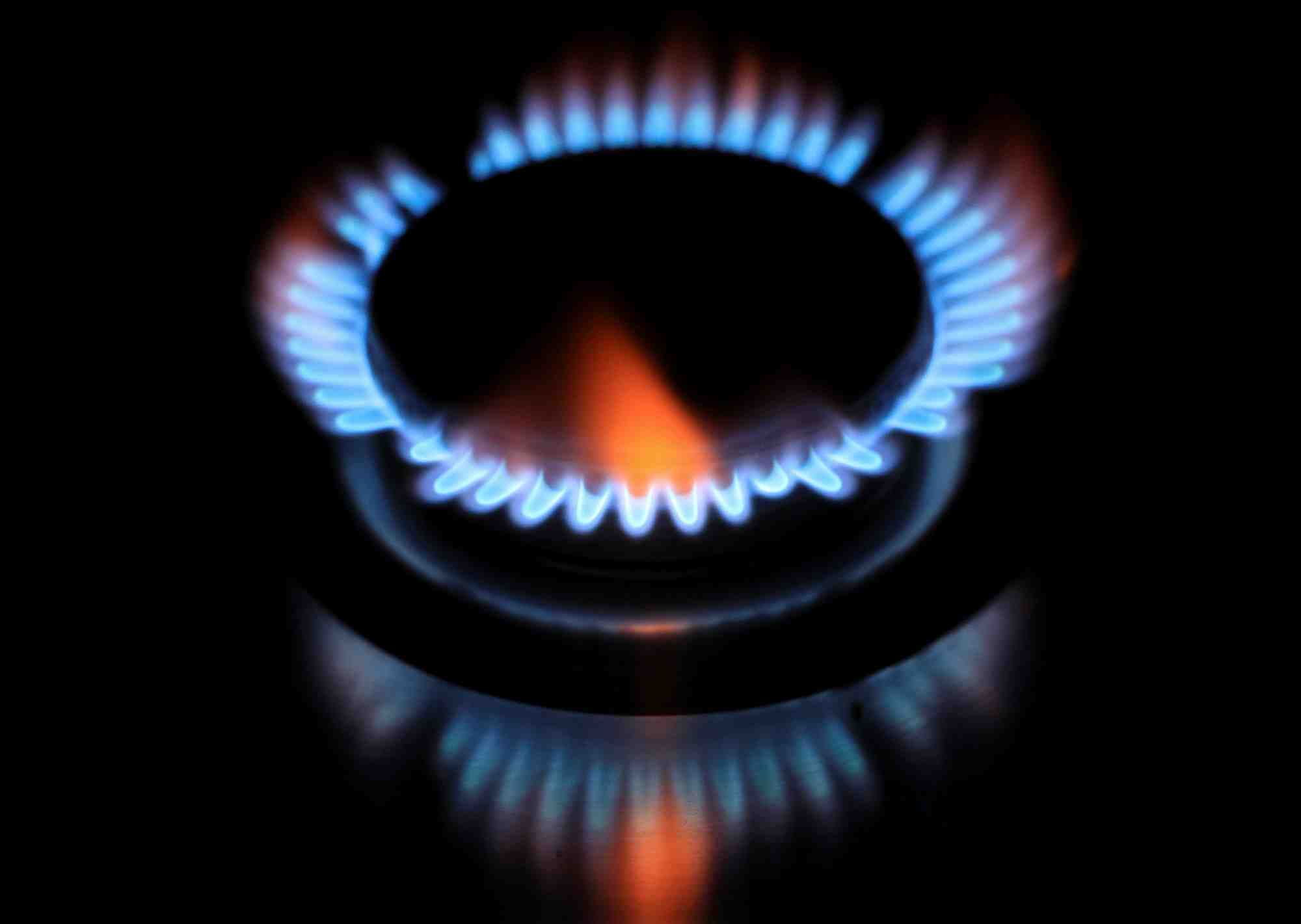 Les flammes d'un bruleur se refletent sur une plaque de cuisson
